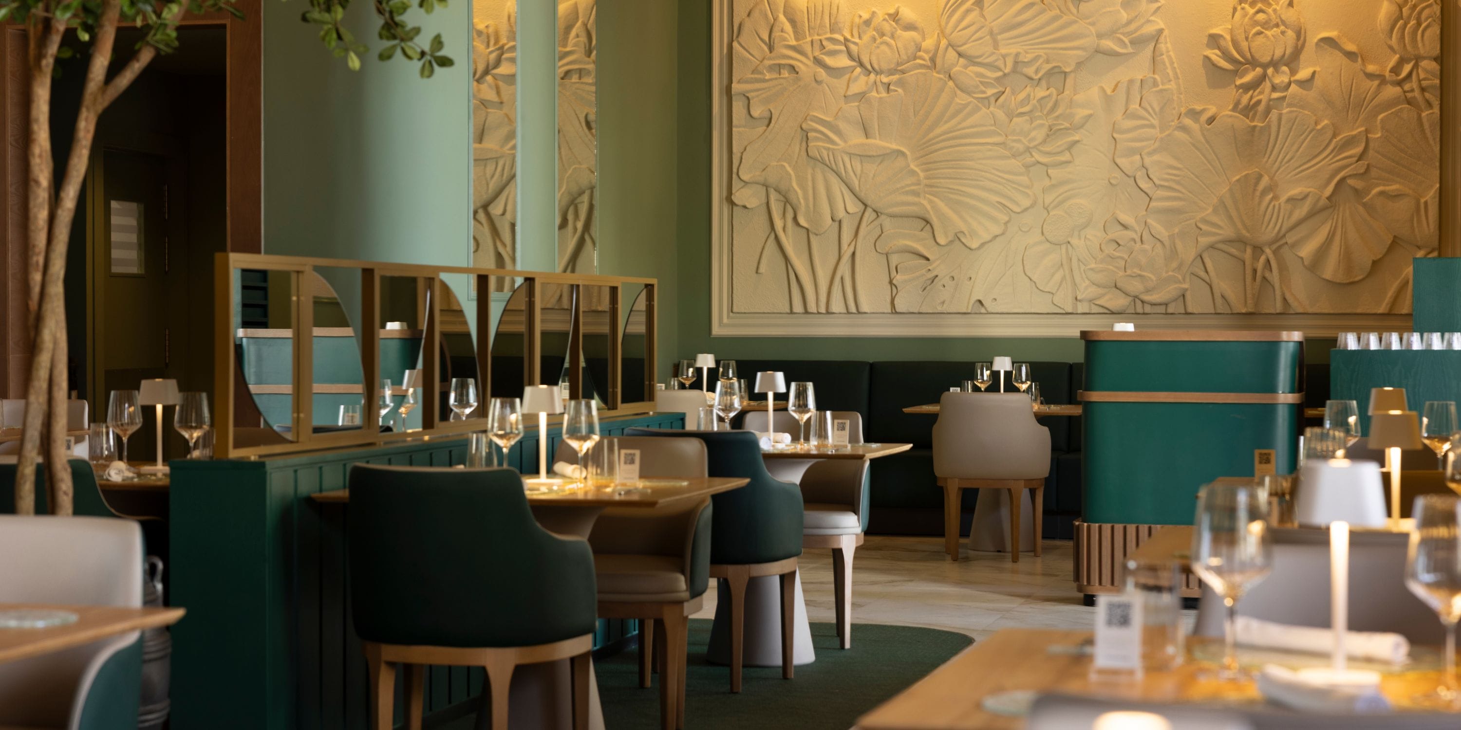 Chic restaurant at Hotel Riu Palace Aruba, perfect for weddings, features green chairs and mural.