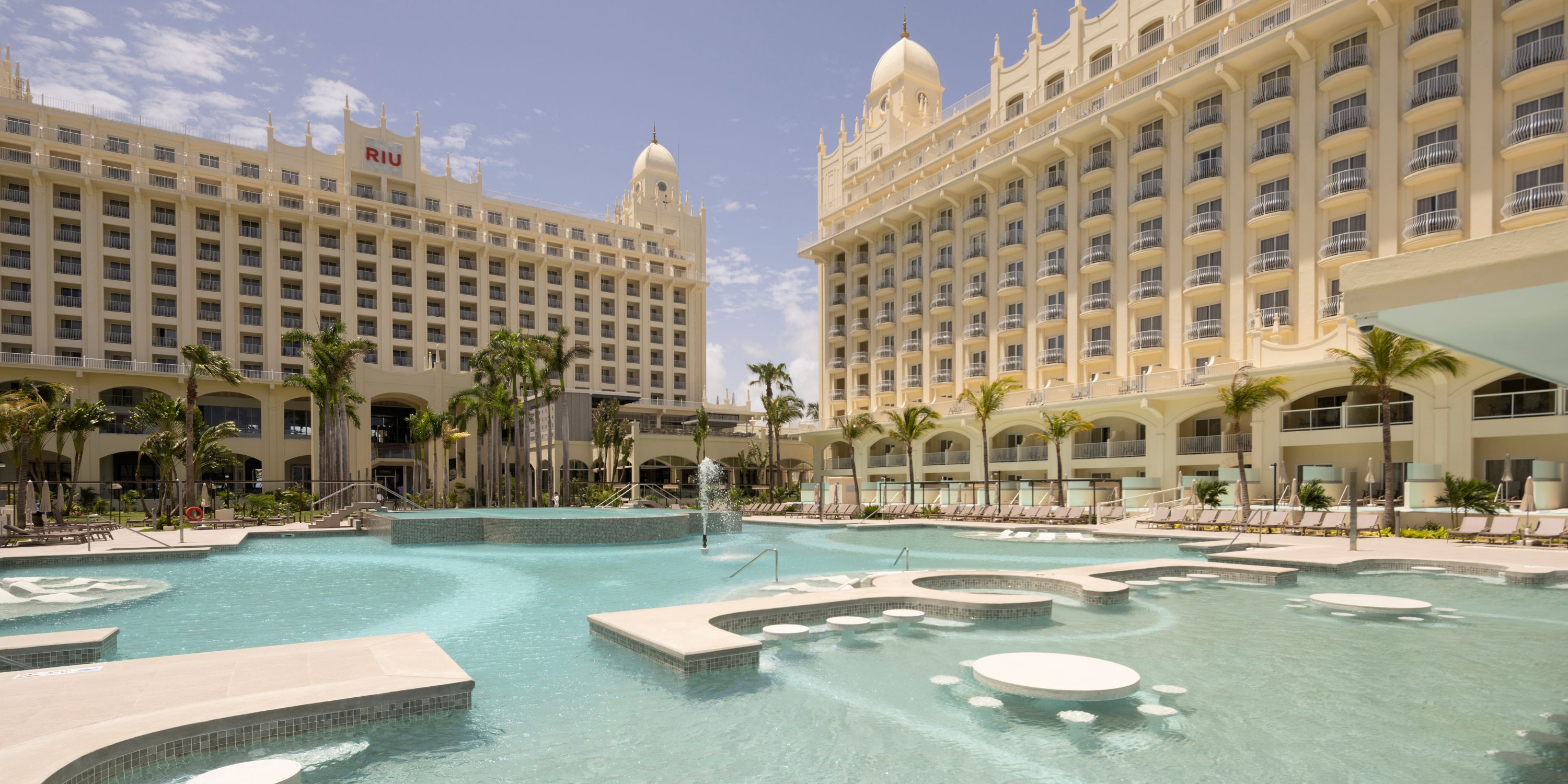Hotel Riu Palace Aruba: ideal for destination weddings, large resort with pool, palms, and loungers.