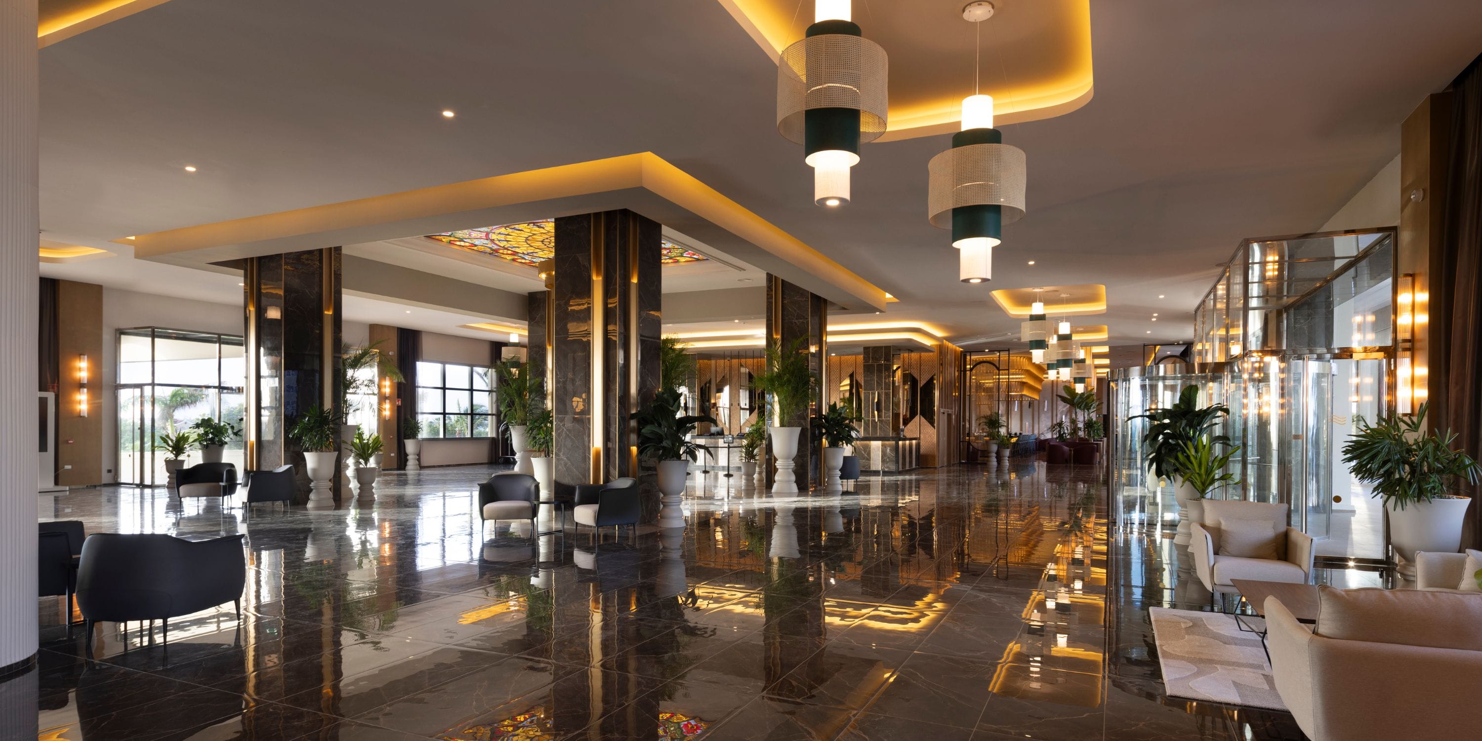 Hotel Riu Palace Aruba: chic lobby with marble floors and bright windows, perfect for weddings.
