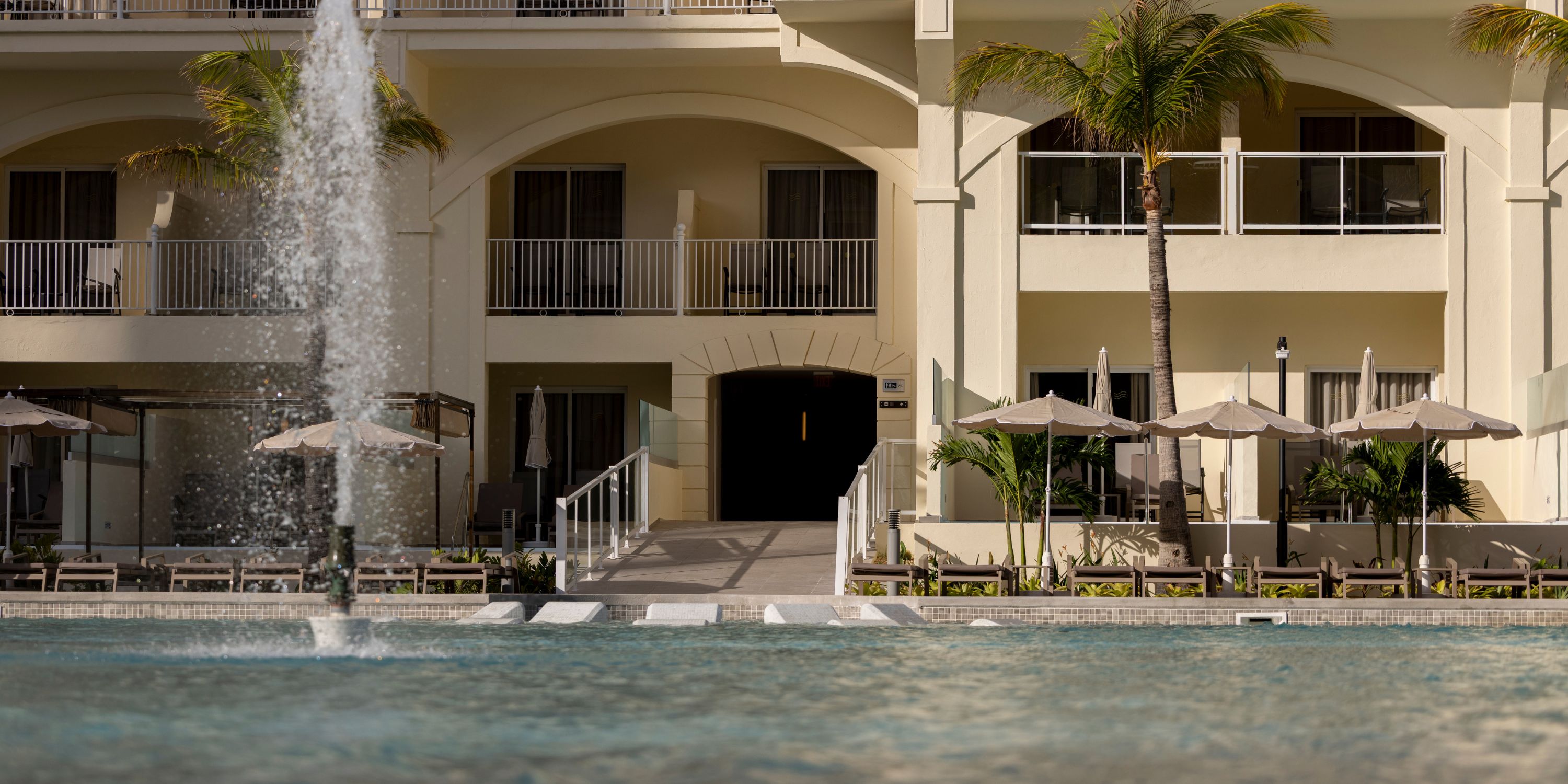 Fountain at Hotel Riu Palace Aruba, a popular destination wedding spot with balconies and umbrellas.