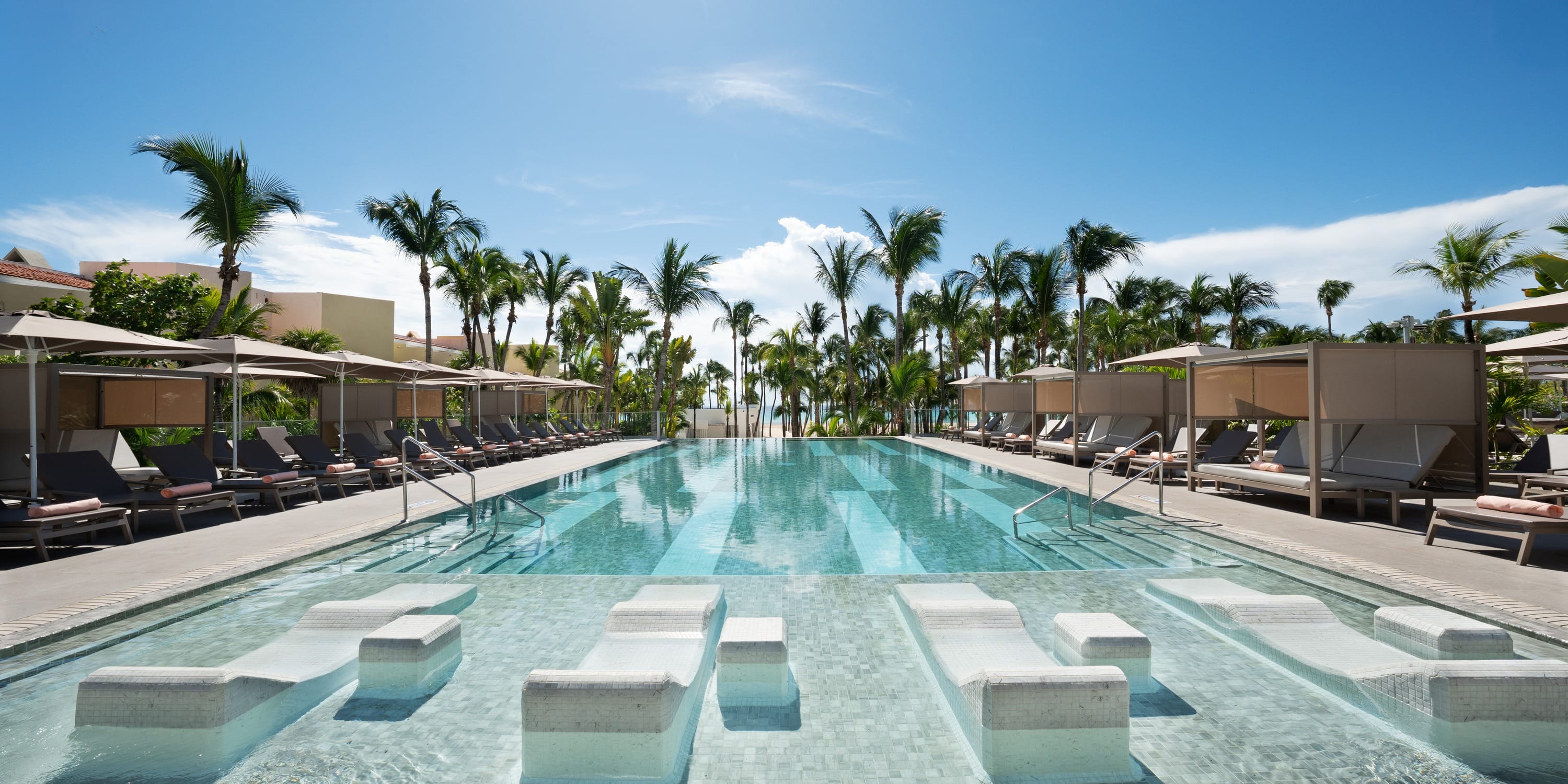 Submerged lounge chairs in a Hotel Riu Palace Mexico pool, perfect for a destination wedding.