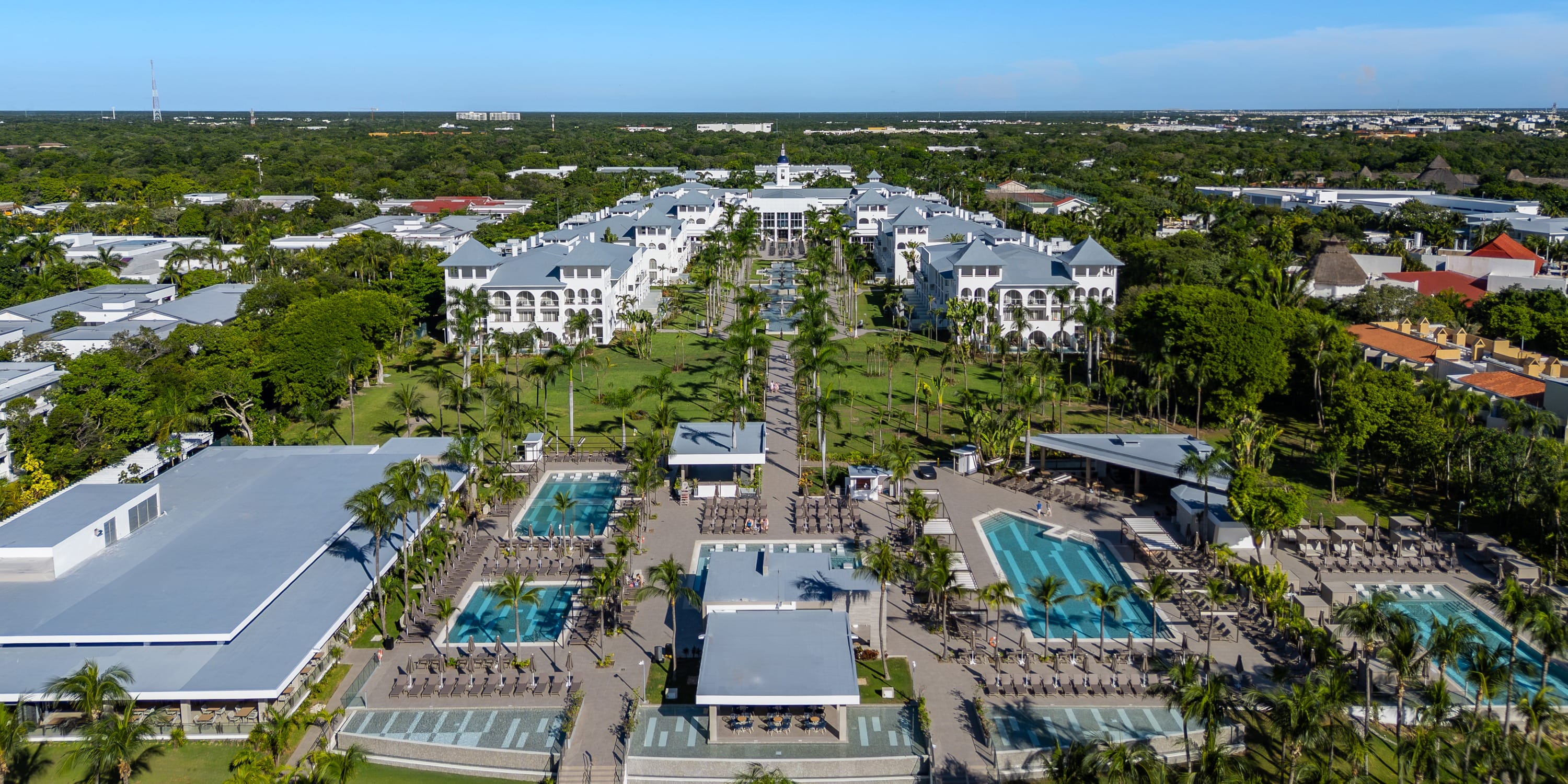 Aerial view of Hotel Riu Palace Mexico with pools and palm trees set for a destination wedding.
