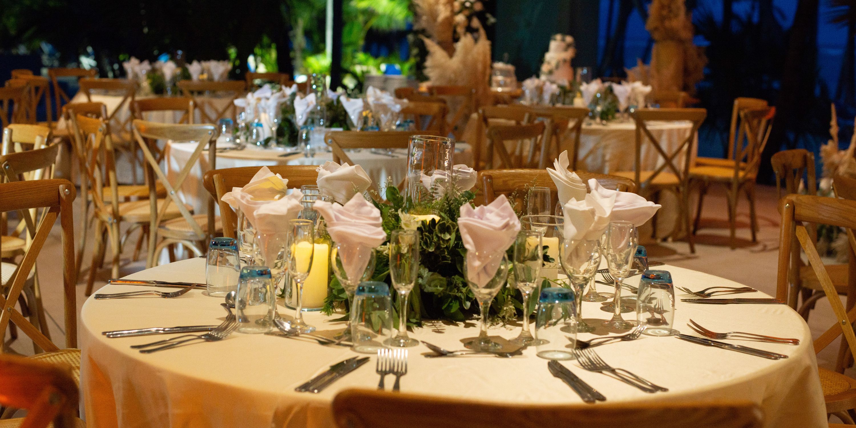 Sophisticated wedding table setting at Hotel Riu Palace Punta Cana with napkins, glassware, and flowers.