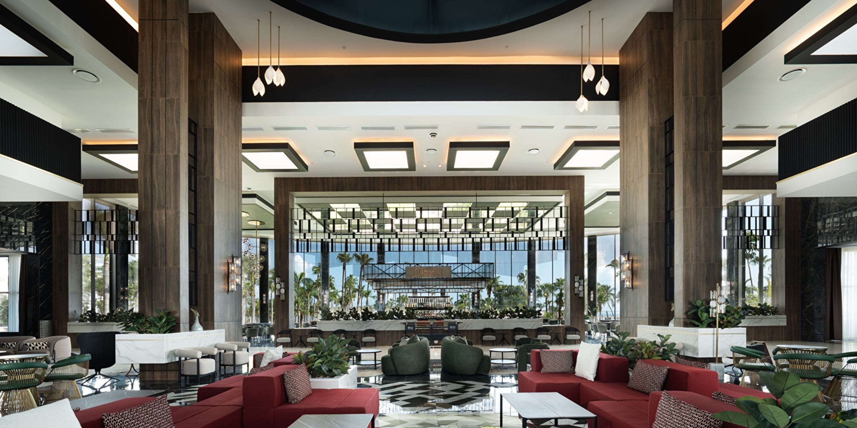 Hotel Riu Palace Peninsula lobby, ideal for destination weddings, with red seats and large windows.