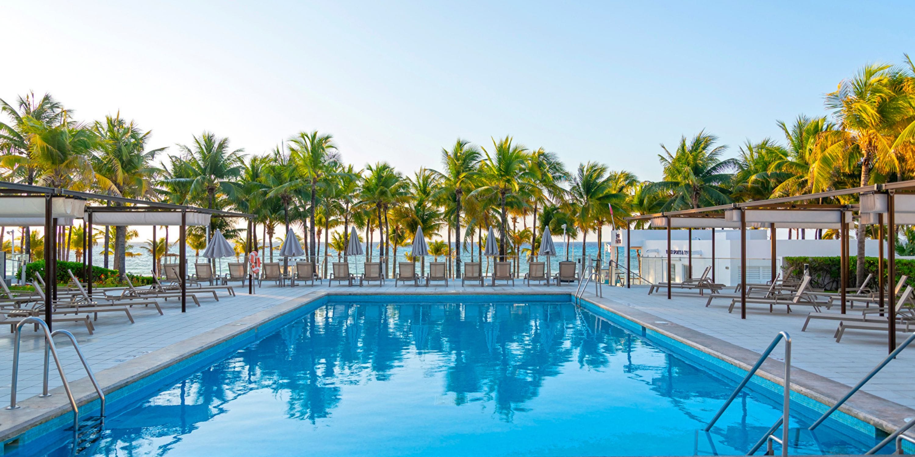 Hotel Riu Palace Riviera Maya: ideal destination wedding spot with pool, lounge chairs, and palm trees.