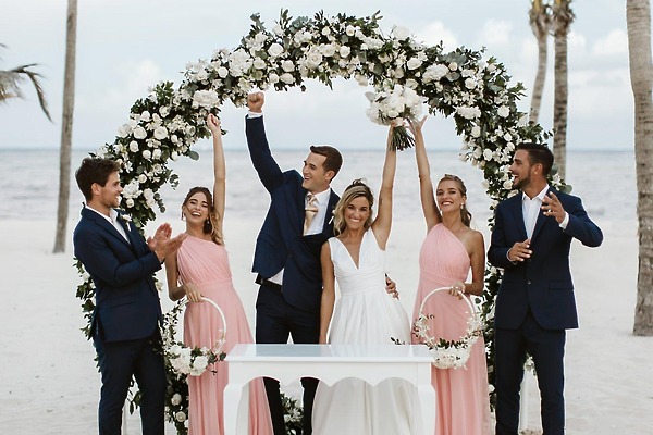 Wedding couple and their party celebrate on the beach at Hotel Riu Palace Bavaro, a destination wedding.