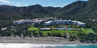 Hotel Riu Guanacaste: A stunning beachfront resort with pools and lush gardens, nestled among green hills—an ideal setting for a romantic destination wedding.