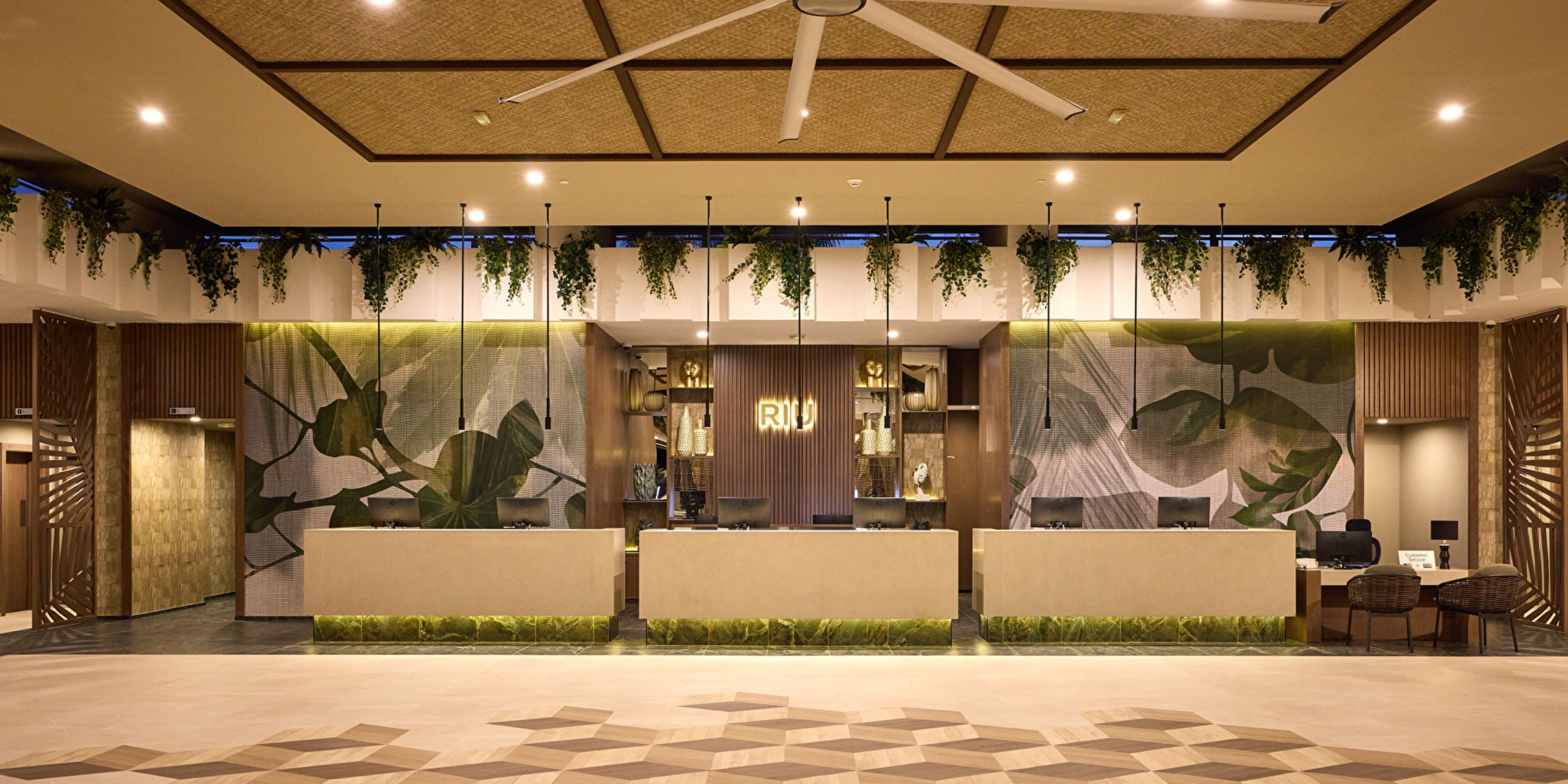 Hotel Riu Guanacaste lobby, perfect for a destination wedding, with four desks and hanging plants.