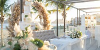 Destination wedding setup at Hotel Riu Palace Baja California featuring a floral arch, cake, and tables.