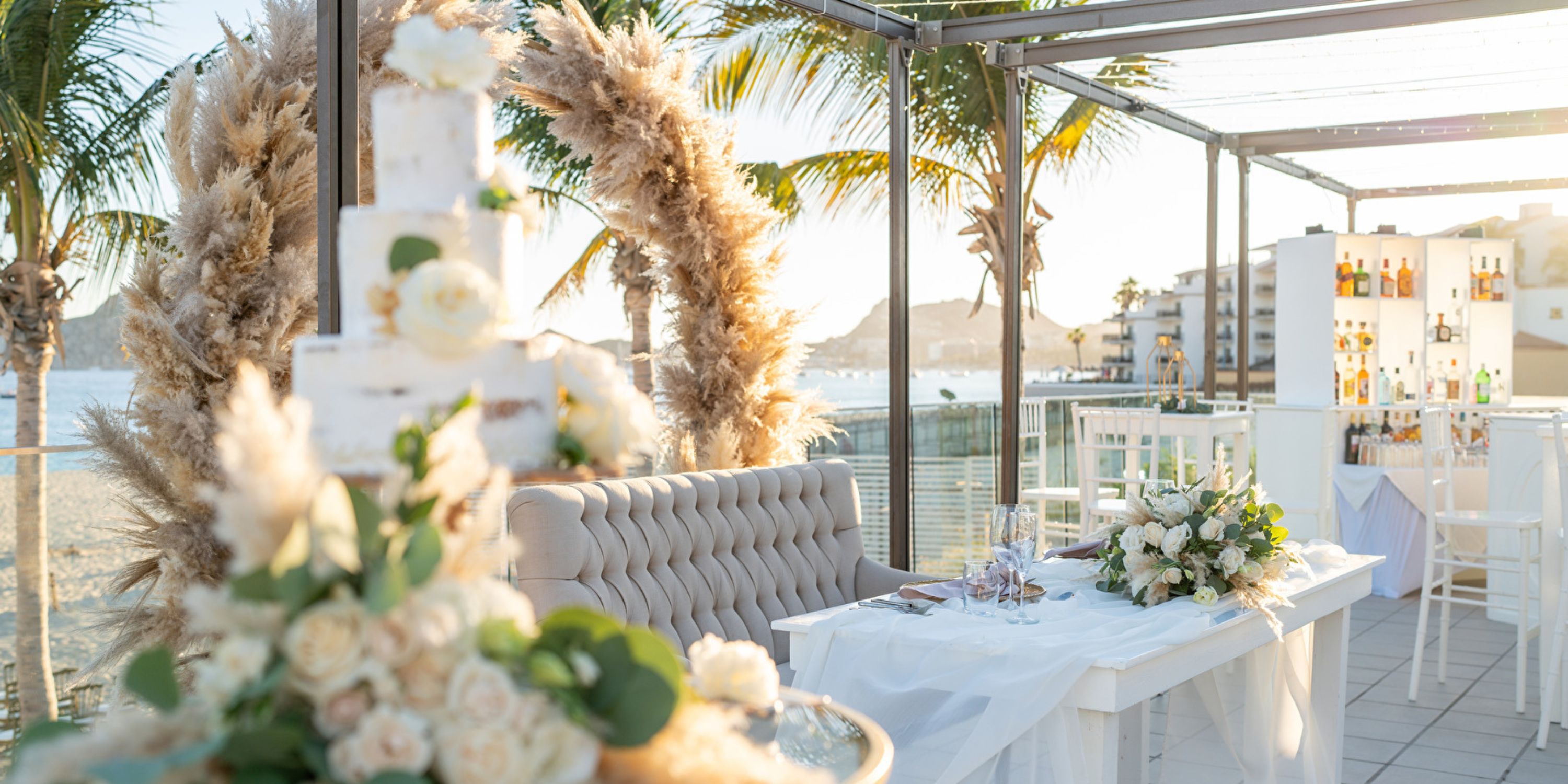 Destination wedding setup at Hotel Riu Palace Baja California featuring a floral arch, cake, and tables.