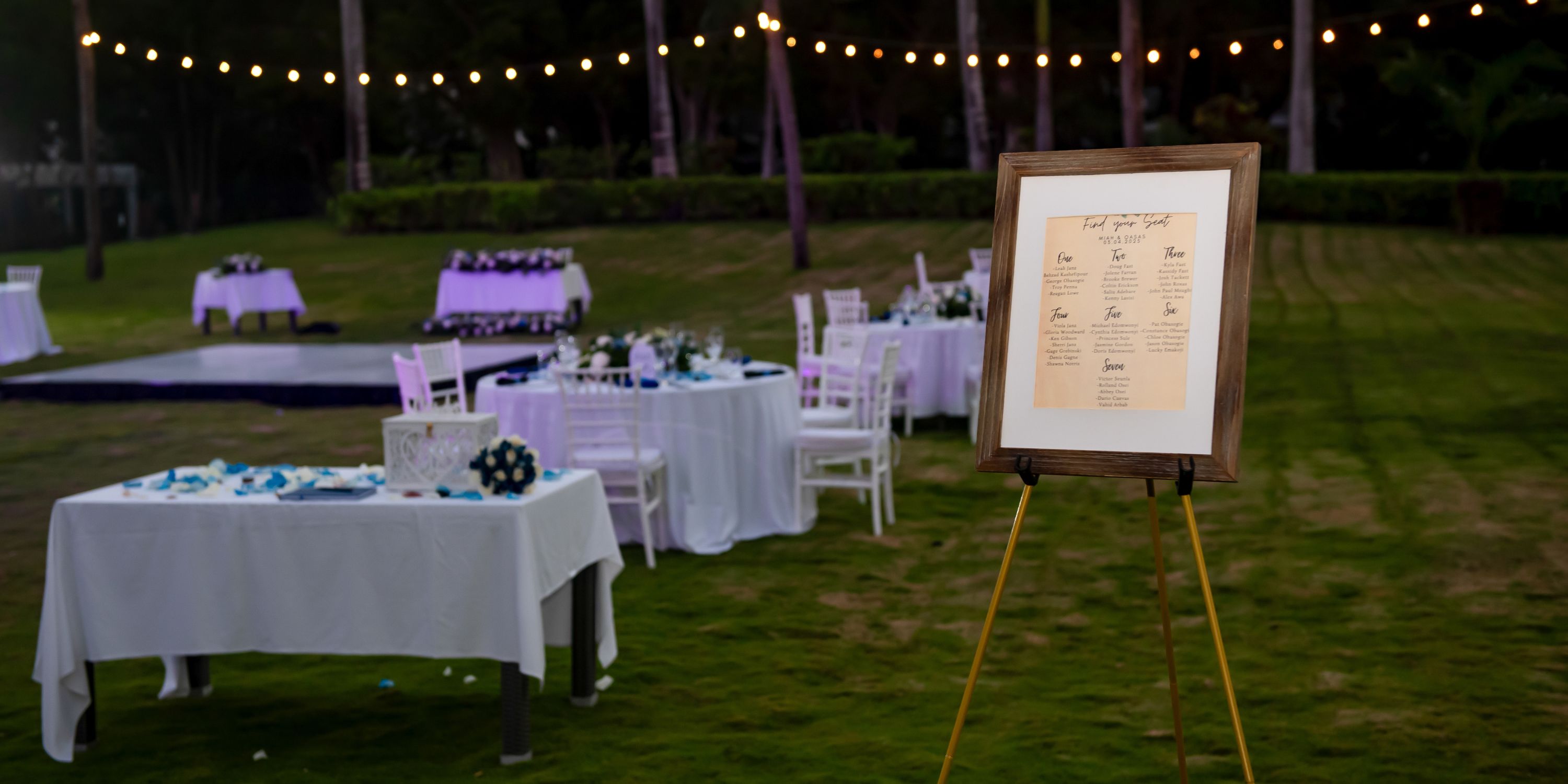Destination wedding setup at Hotel Riu Palace Mexico with round tables, chairs, and a seating chart outdoors.