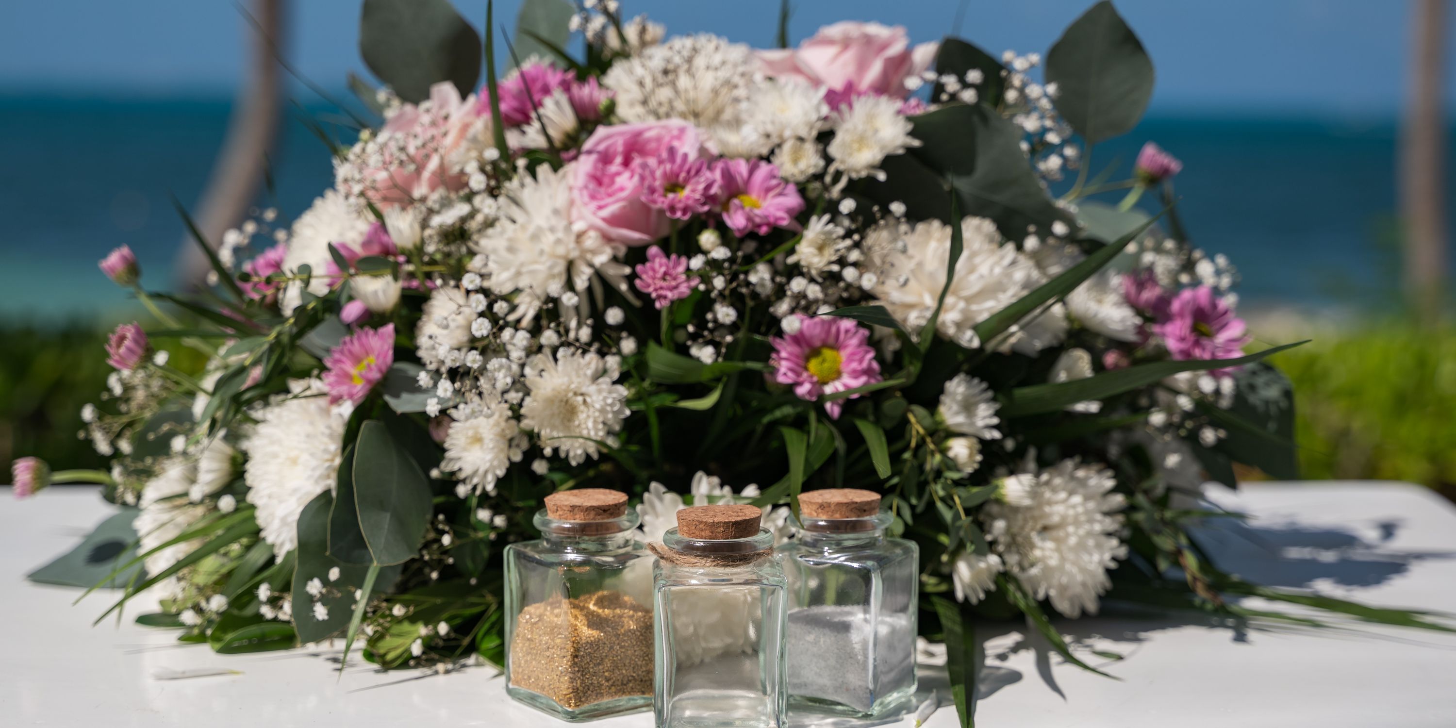 Hotel Riu Palace Peninsula set before a bouquet of pink and white flowers, perfect for a destination wedding.