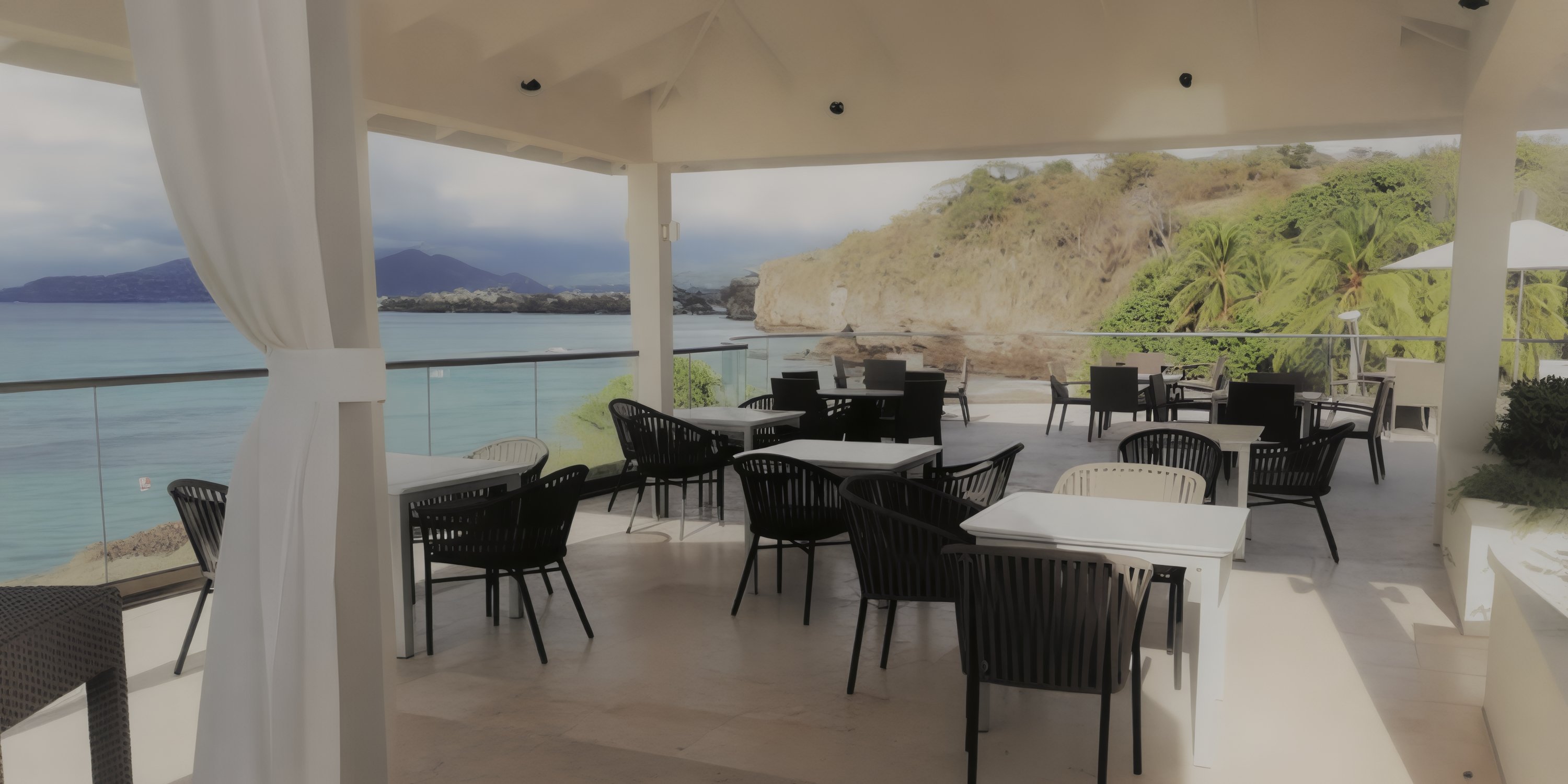 Outdoor patio at Royalton Grenada set for a destination wedding, with tables and chairs overlooking ocean.