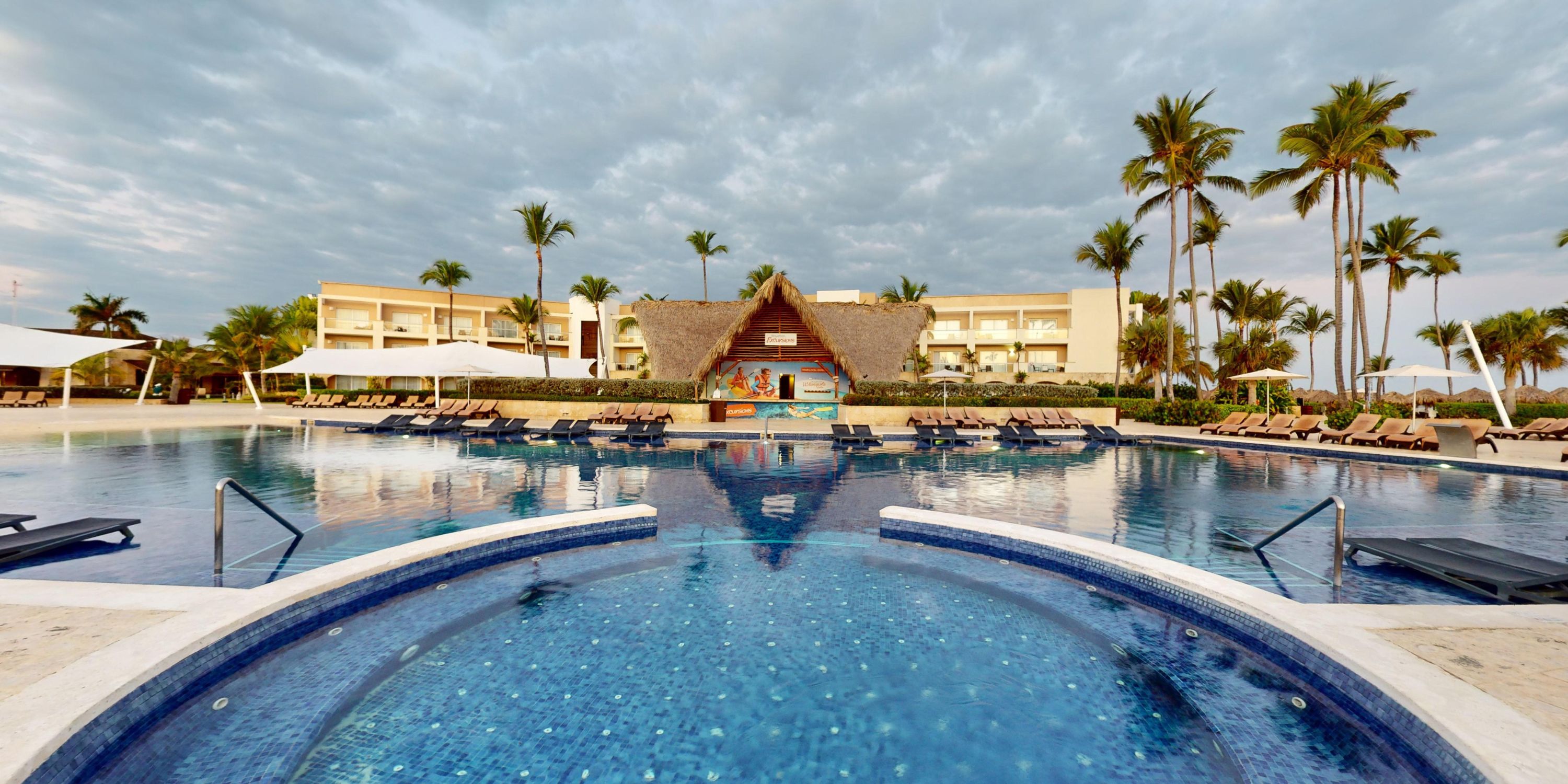 Large resort pool at Royalton Splash Punta Cana, a stunning destination wedding spot with palm trees.