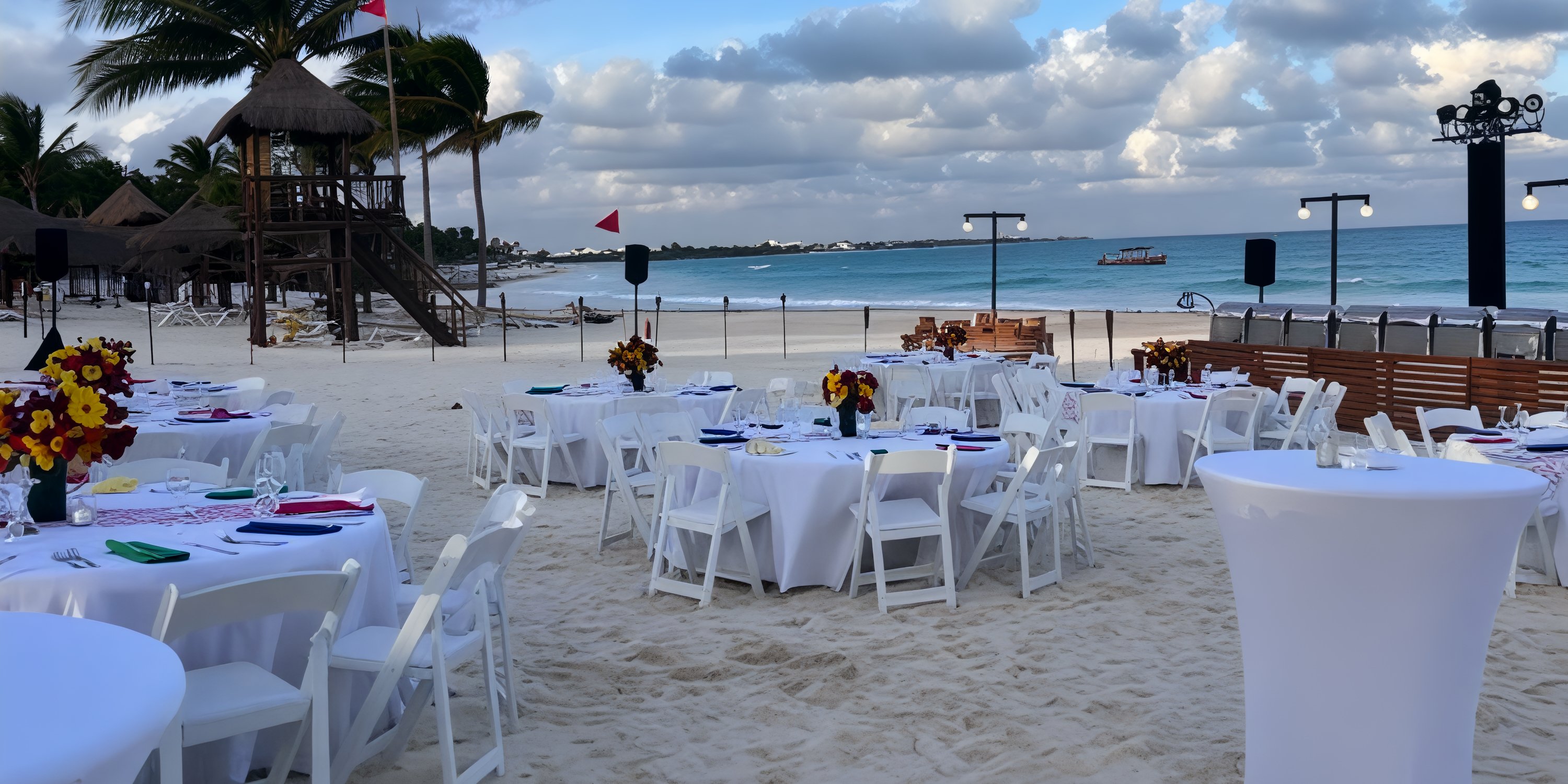 Destination wedding setup at Secrets Maroma Beach with round tables, white chairs, and oceanfront decor.