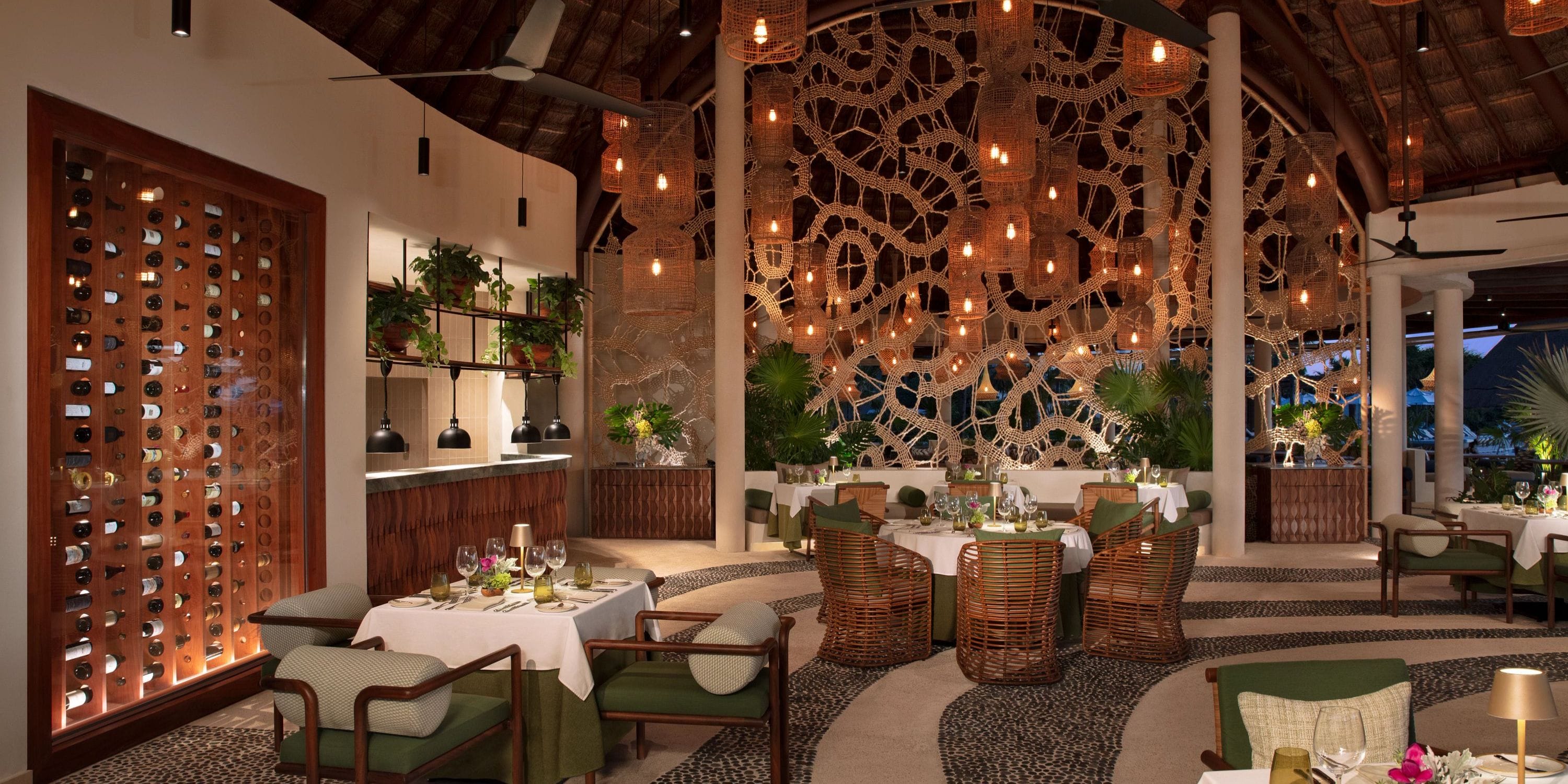 Destination wedding setup at Secrets Maroma Beach with woven d&eacute;cor, round tables, and wicker chairs.