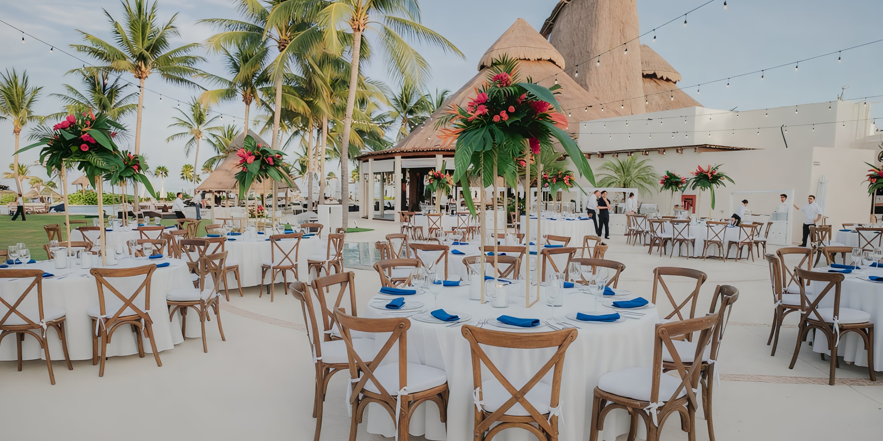 Destination wedding reception at Secrets Maroma Beach with round tables, white linens, and tropical decor.