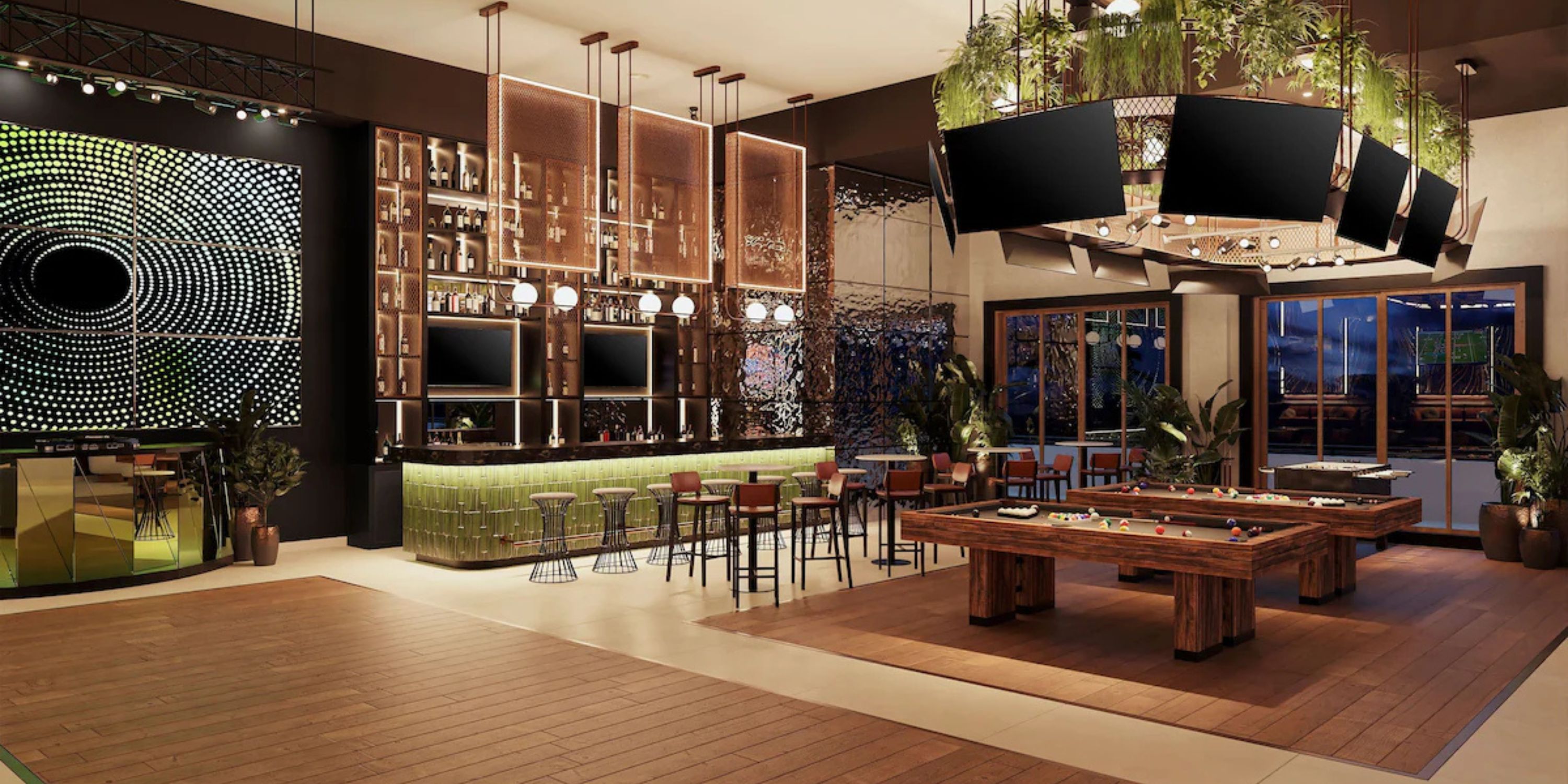 Secrets Playa Mujeres features a stylish bar&mdash;perfect for a destination wedding&mdash;with pool tables, green stools, and lush plants.