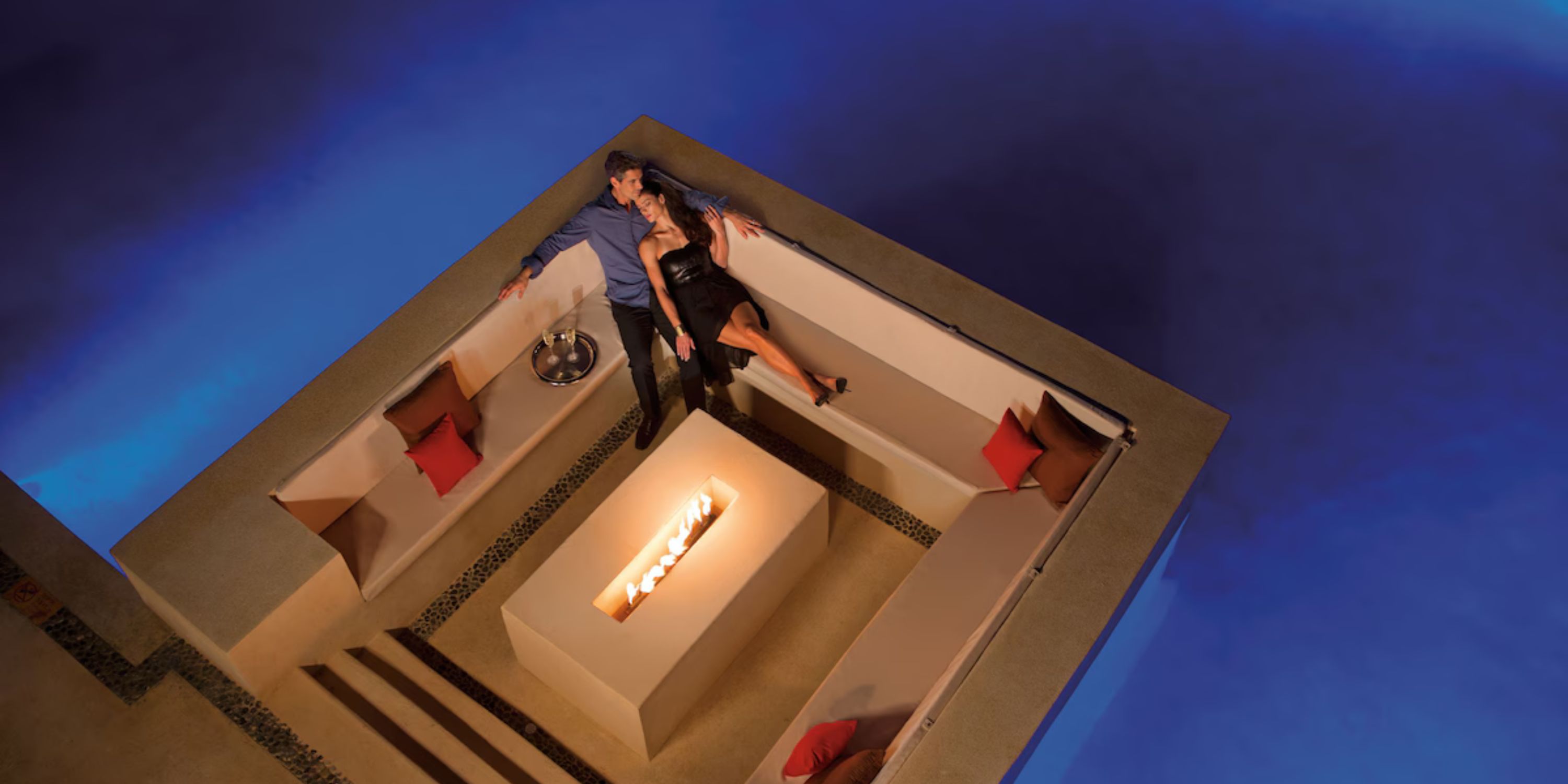 A couple enjoys a cozy fire pit at Secrets Playa Mujeres, perfect for a romantic destination wedding.