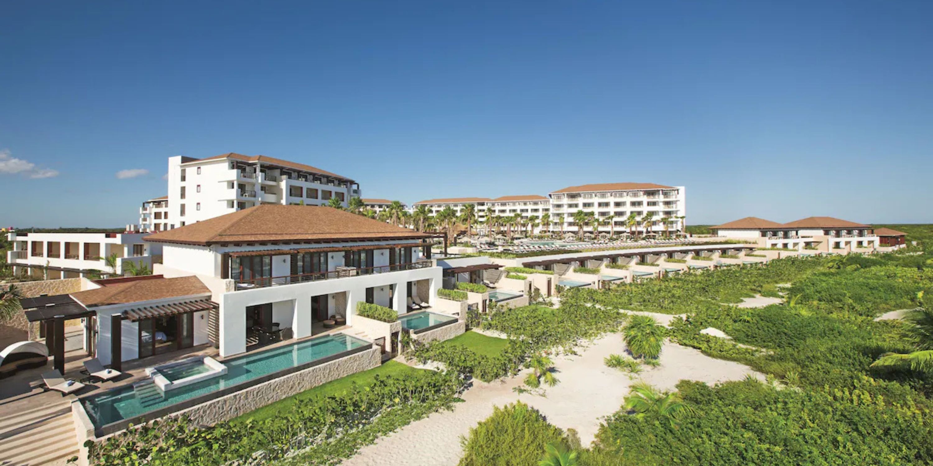 Secrets Playa Mujeres: a stunning destination wedding resort with pools, white buildings, and lush greenery.