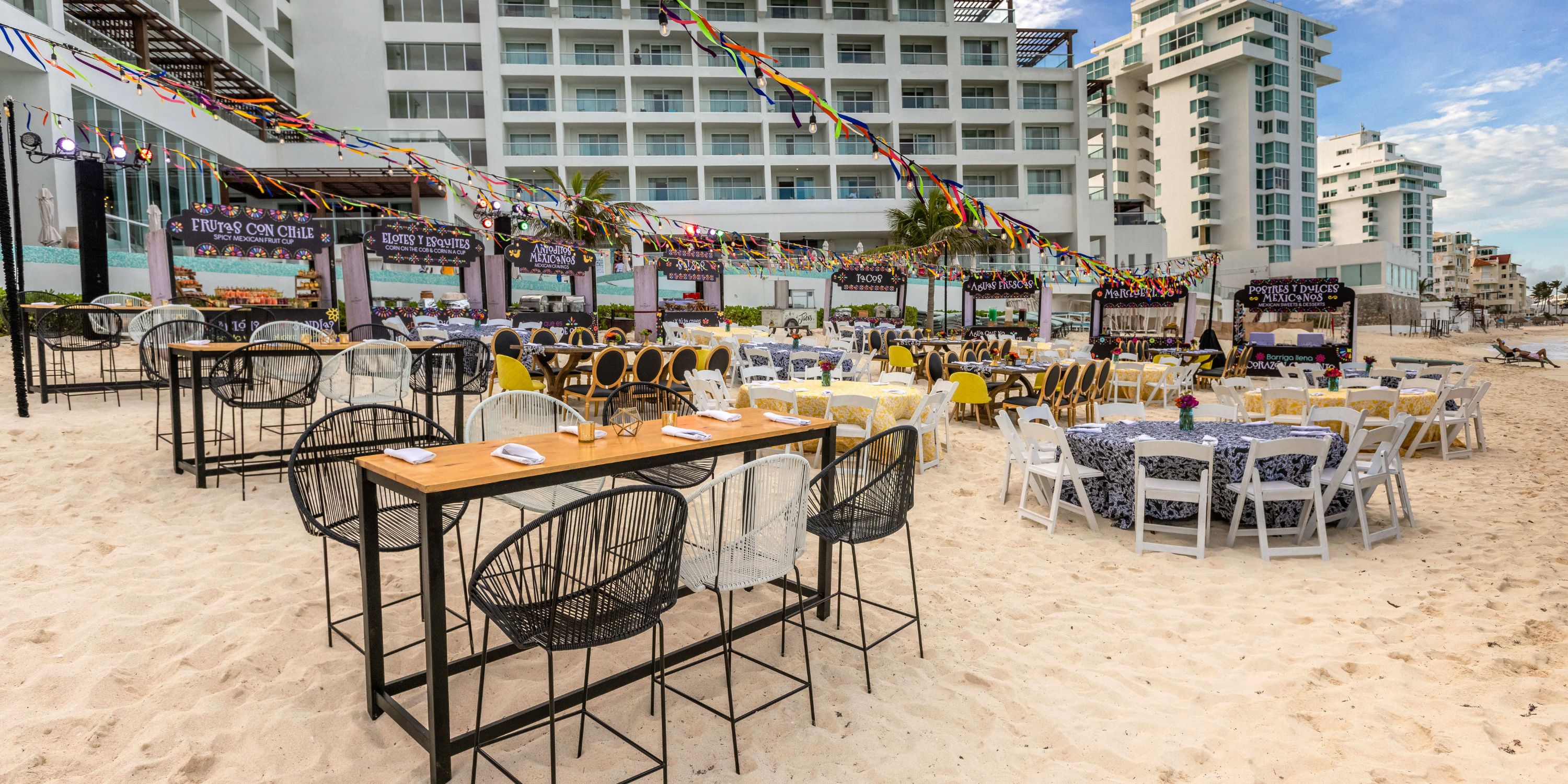 Beachfront dining setup at Playacar Palace, ideal for a destination wedding, with tables and string lights.