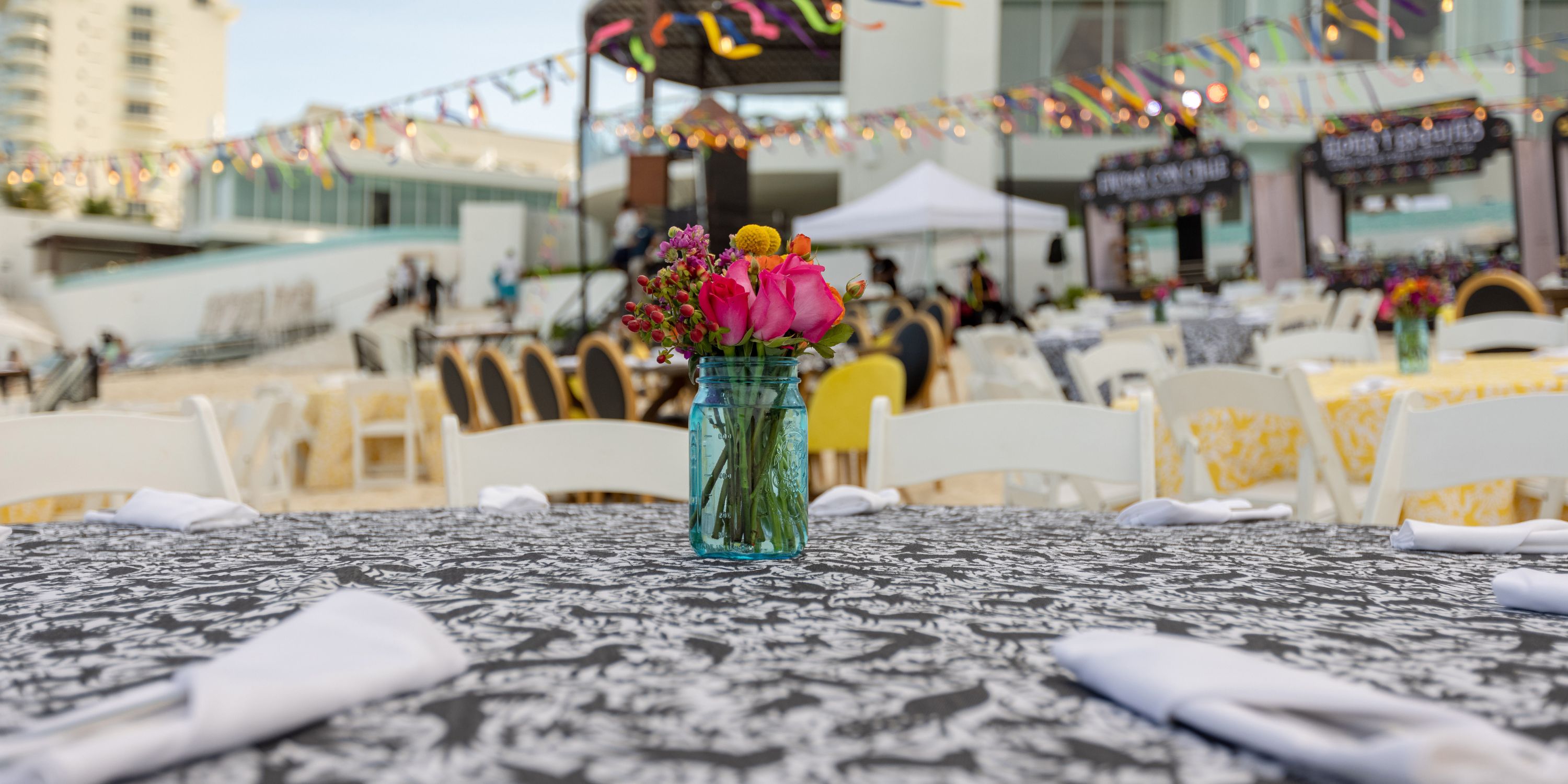 Outdoor table at Playacar Palace elegantly set with florals and napkins for a destination wedding event.