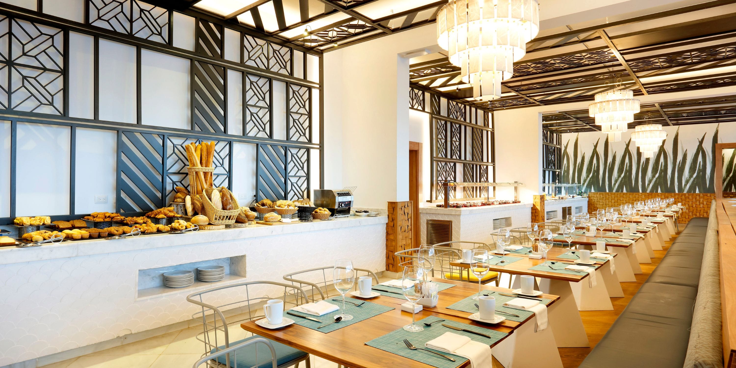 TRS Turquesa restaurant set for a destination wedding, with tables and a buffet of assorted pastries.