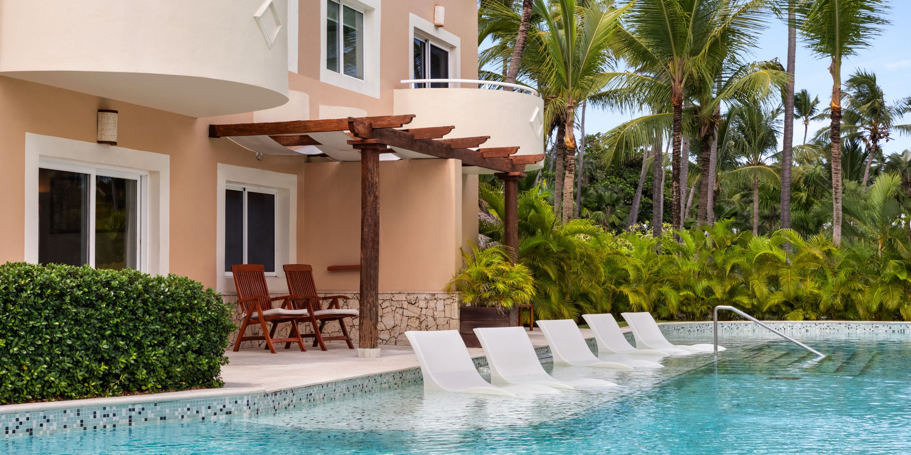 TRS Turquesa lounge chairs partly submerged in a pool, perfect for a destination wedding setting.
