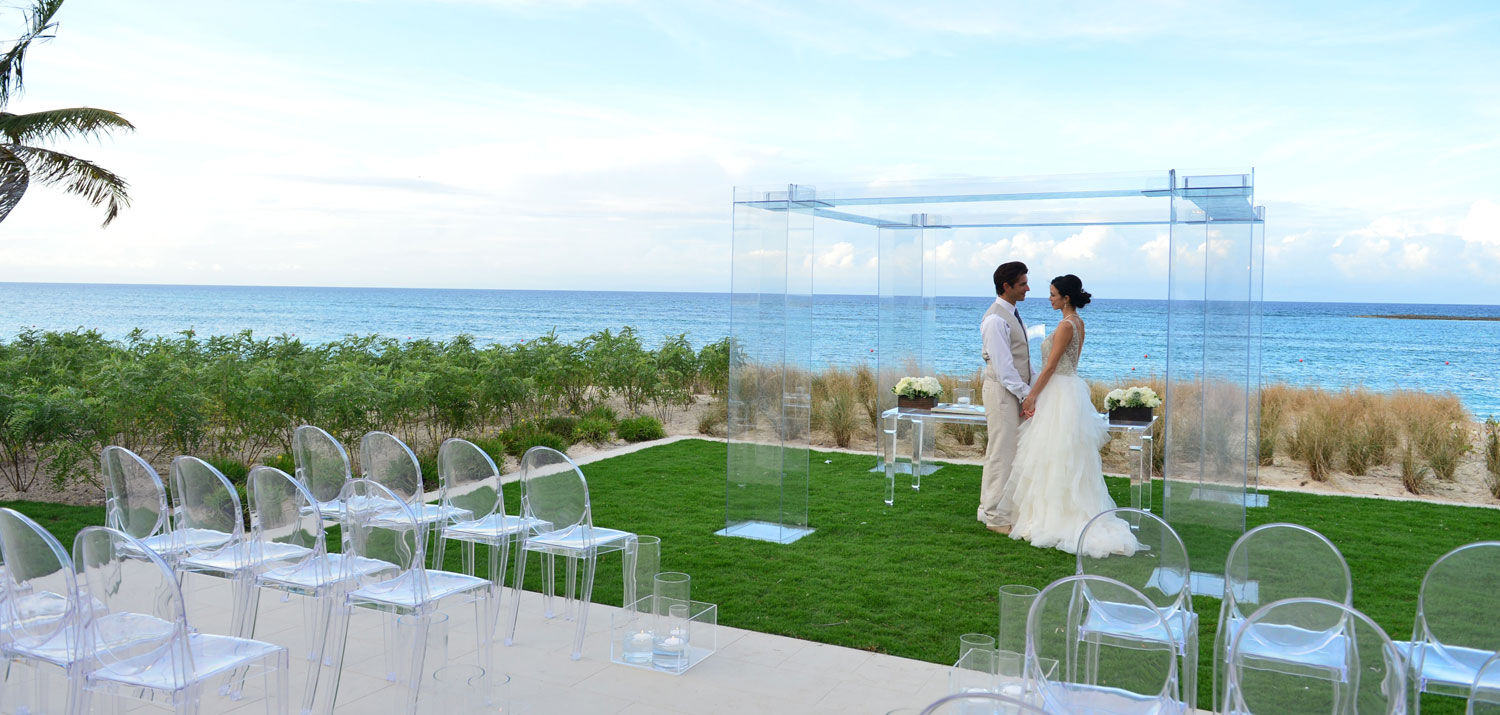 A bride and groom standing in front of The Cove at Atlantis arch at their wedding.