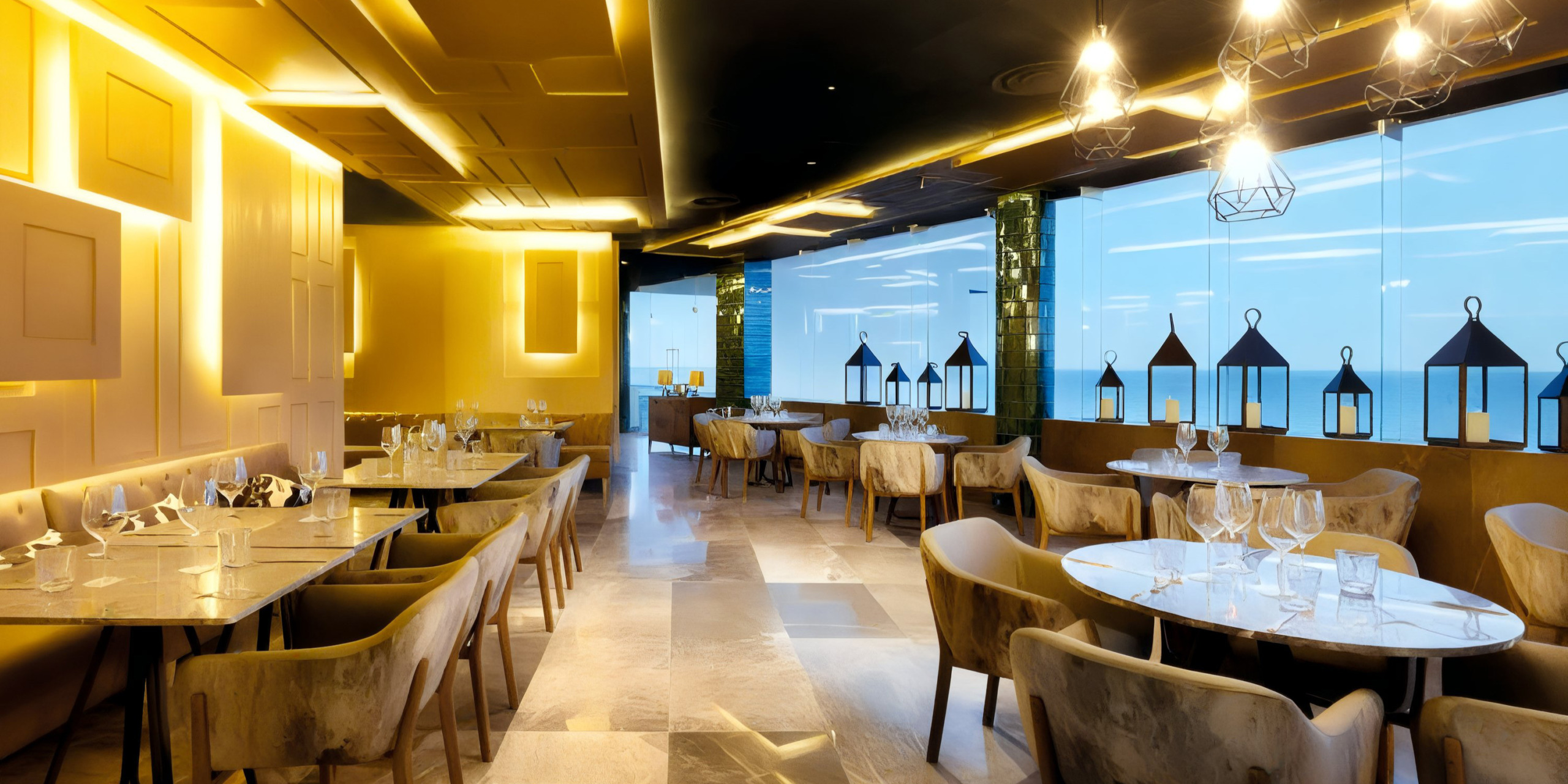 The TRS Coral Hotel features a modern and elegant ambiance with marble tables, plush chairs, and floor-to-ceiling windows, complemented by lantern-style lights hanging from the ceiling.