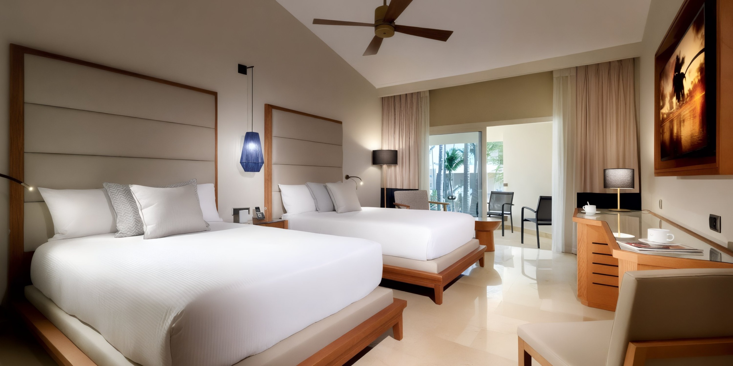Experience the Grand Palladium Punta Cana with a hotel room featuring two double beds, a ceiling fan, and modern decor. Enjoy amenities such as a desk, a seating area, and a balcony with glass doors that fill the room with natural light.