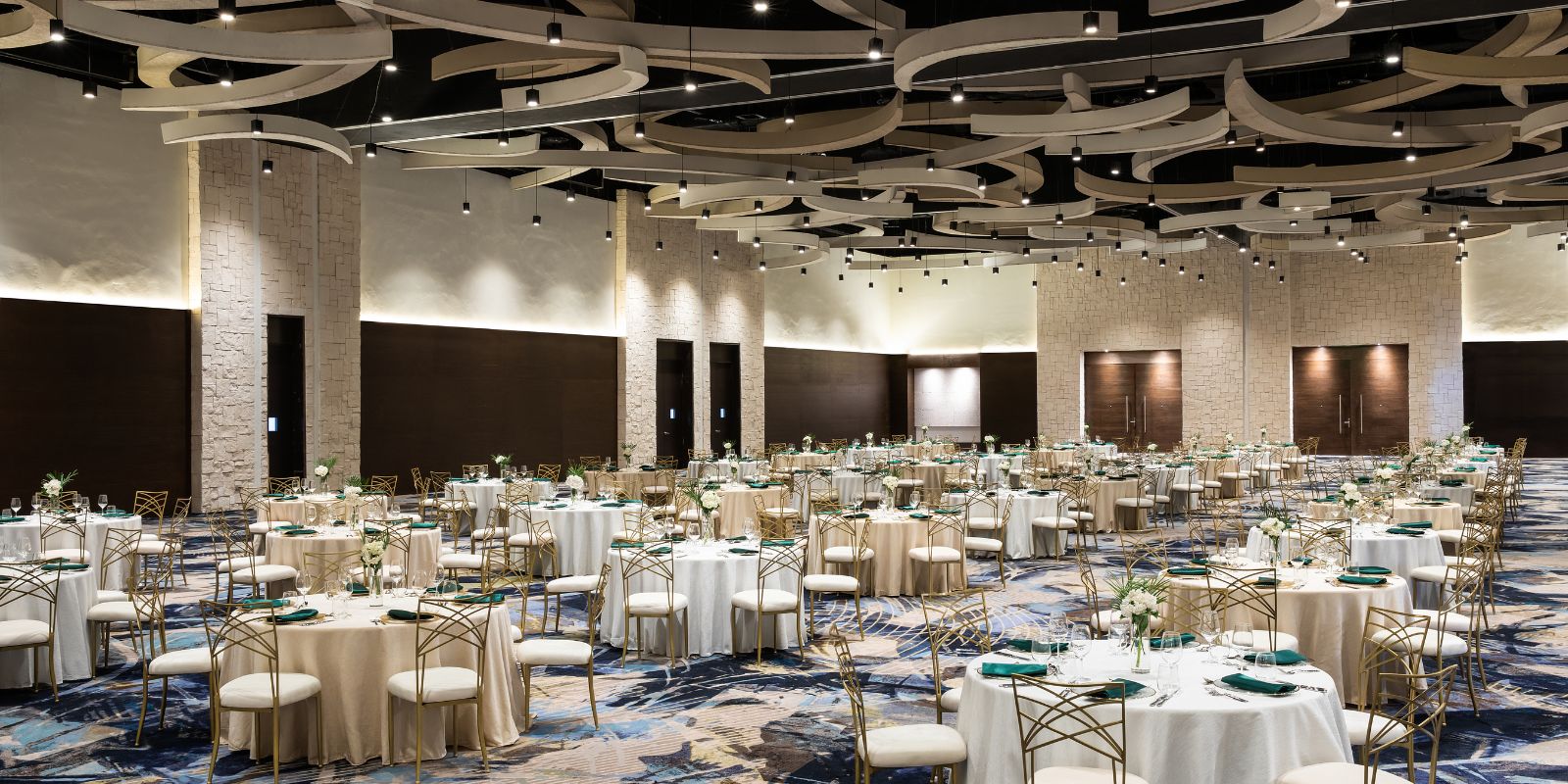 A Hyatt Ziva Cap Cana banquet hall with tables and chairs set up.