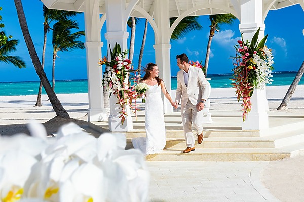 A bride and groom standing in front of a gazebo on the beach at their Hyatt Ziva Cap Cana wedding.