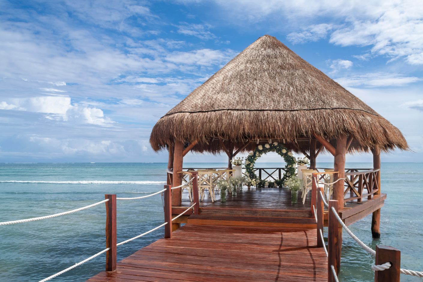 Intimate elegance wedding package on a pier under a thatched roof palapa gazebo on the sea at Hyatt Ziva Riviera Cancun