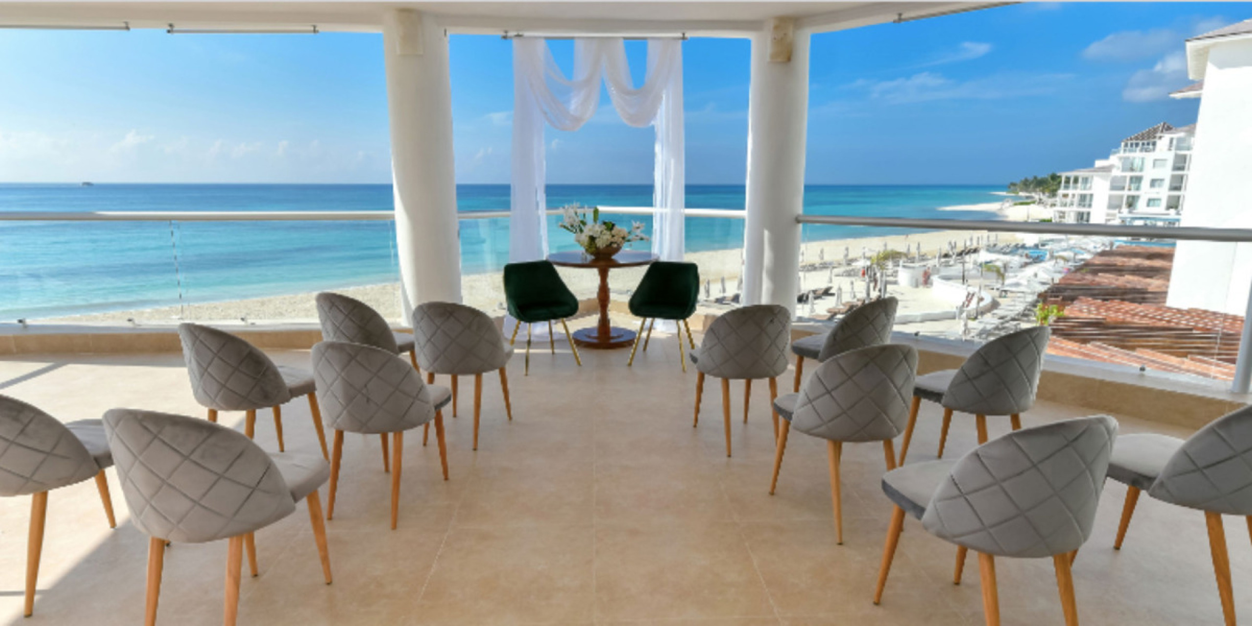 Outdoor gazebo venue space with chairs set up for a destination wedding with the ocean in the distance
