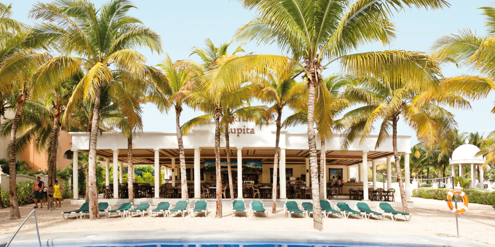 A Hotel Riu Lupita with lounge chairs and palm trees.