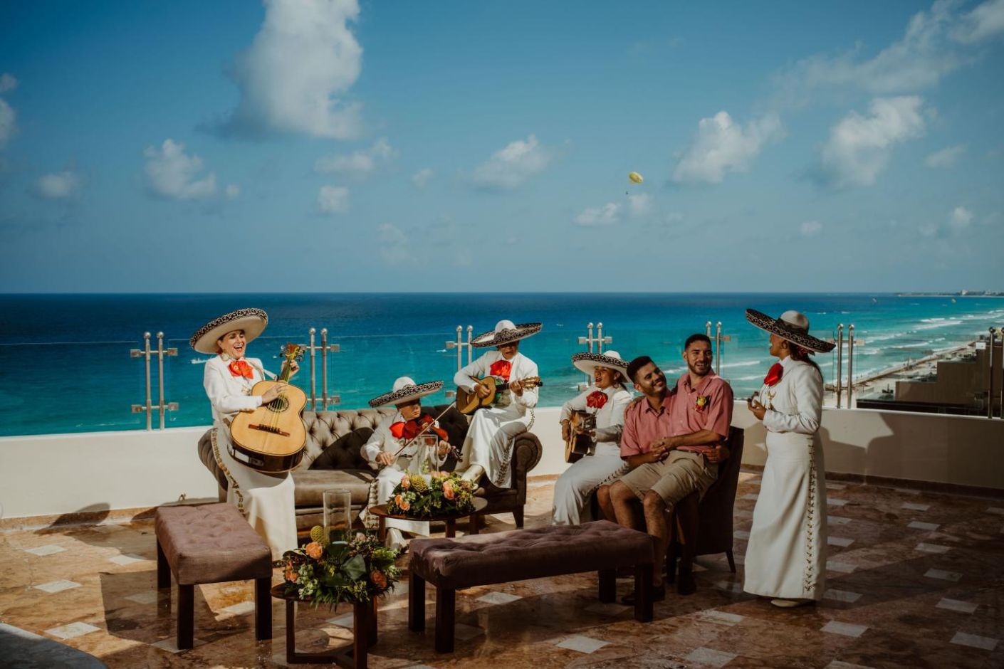 A group of people playing music on a balcony overlooking the ocean at Sandos Cancun Lifestyle Resort.