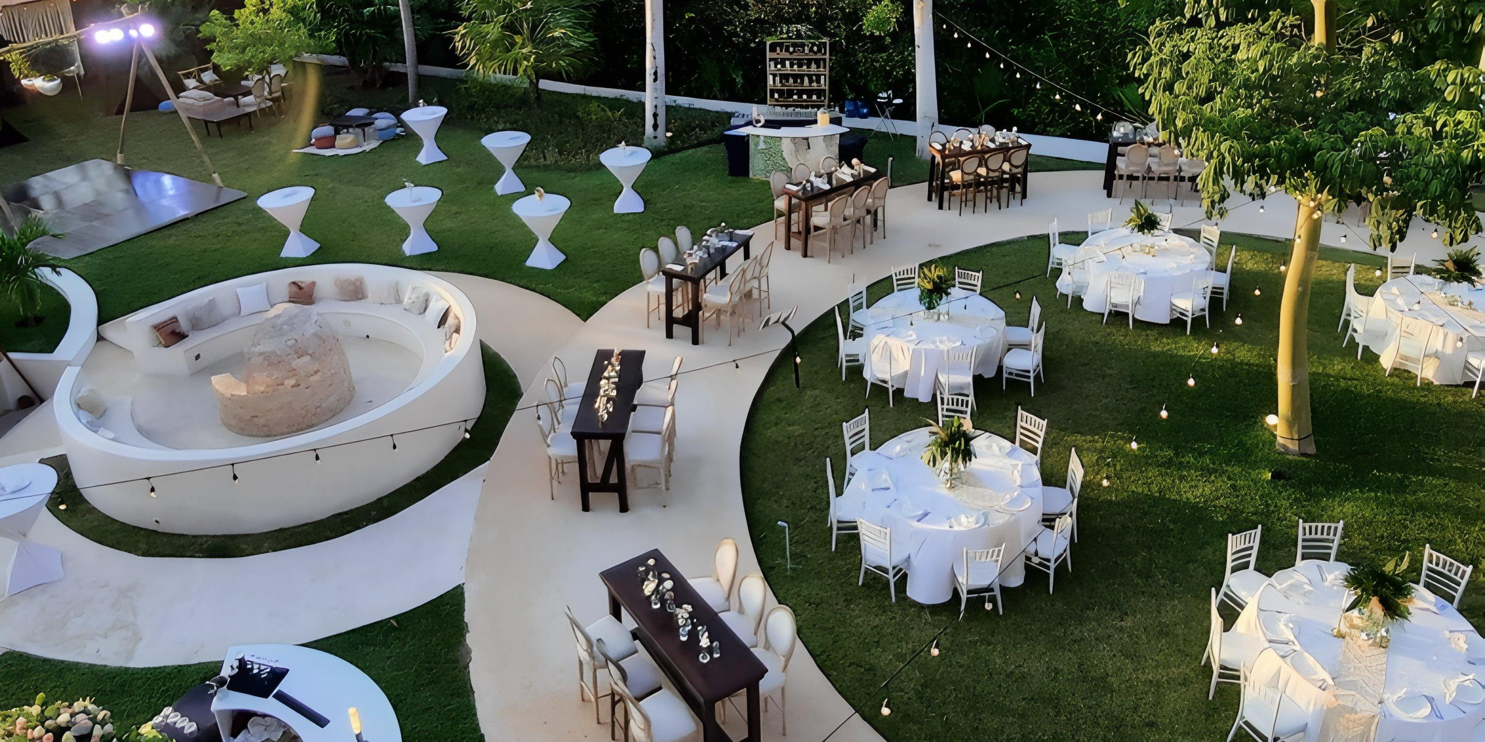 Destination wedding setup at Haven Riviera Cancun featuring round tables, high-tops, and a grass lounge.