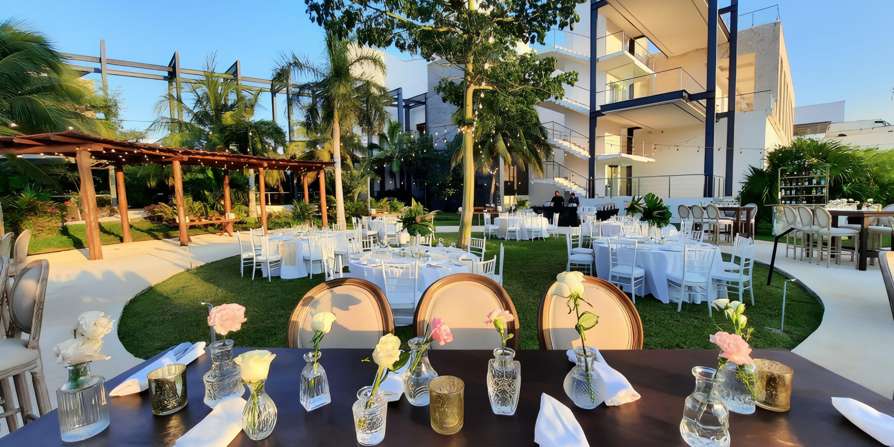 Haven Riviera Cancun: Destination wedding venue outdoors with round tables, white chairs, and florals.