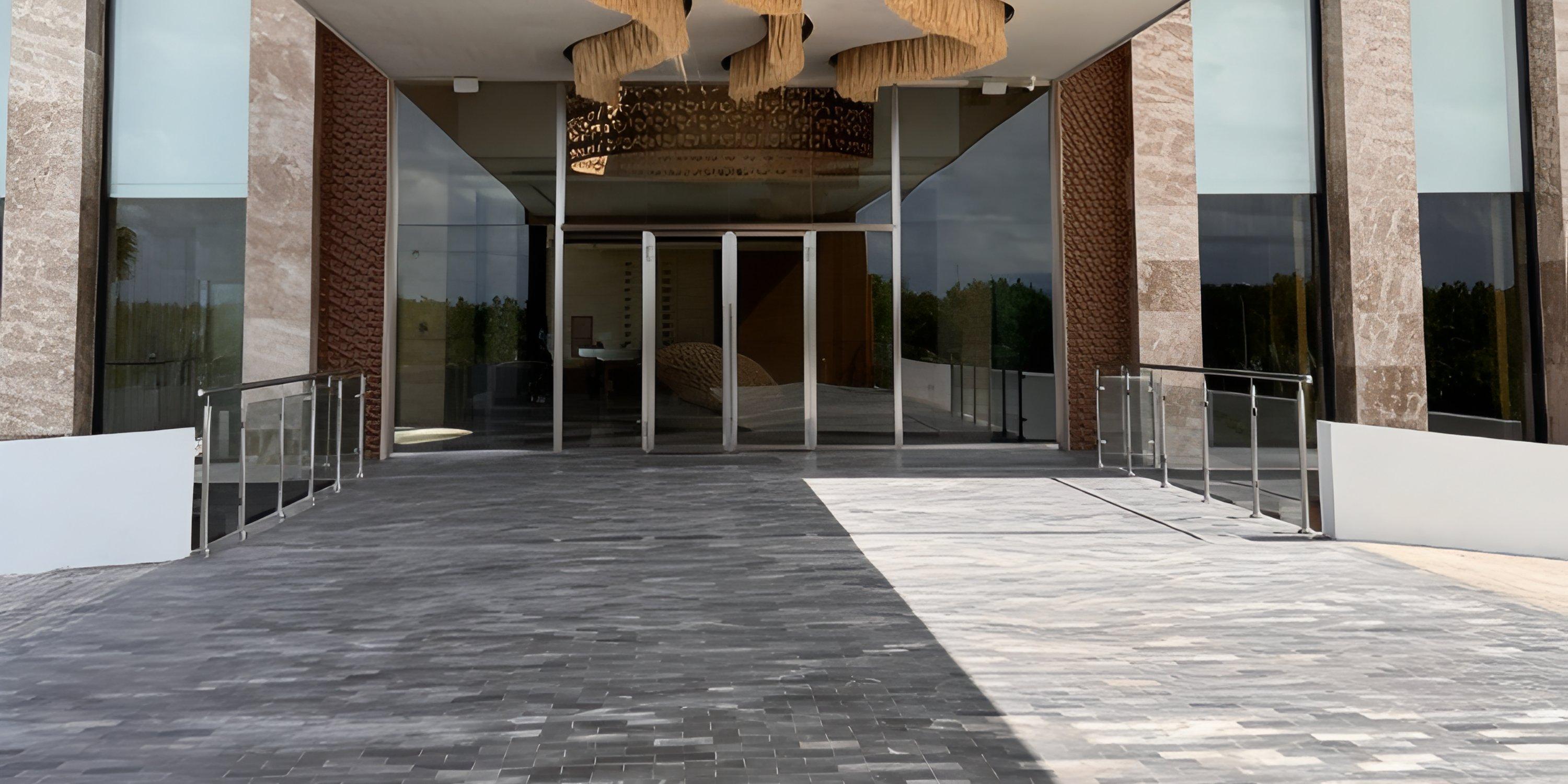 Haven Riviera Cancun entrance, ideal for a destination wedding, has glass doors, ramps, and modern lighting.