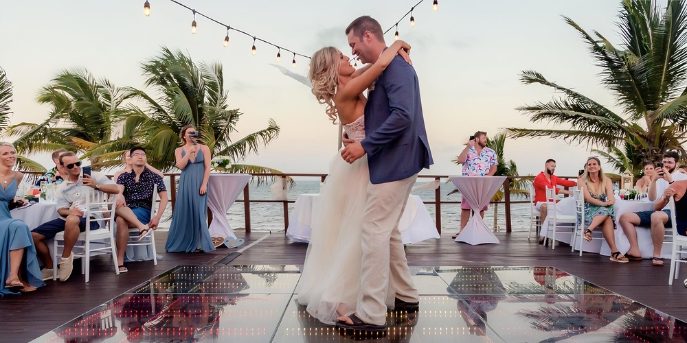 A couple shares their first dance at a destination wedding at Haven Riviera Cancun, guests seated nearby.