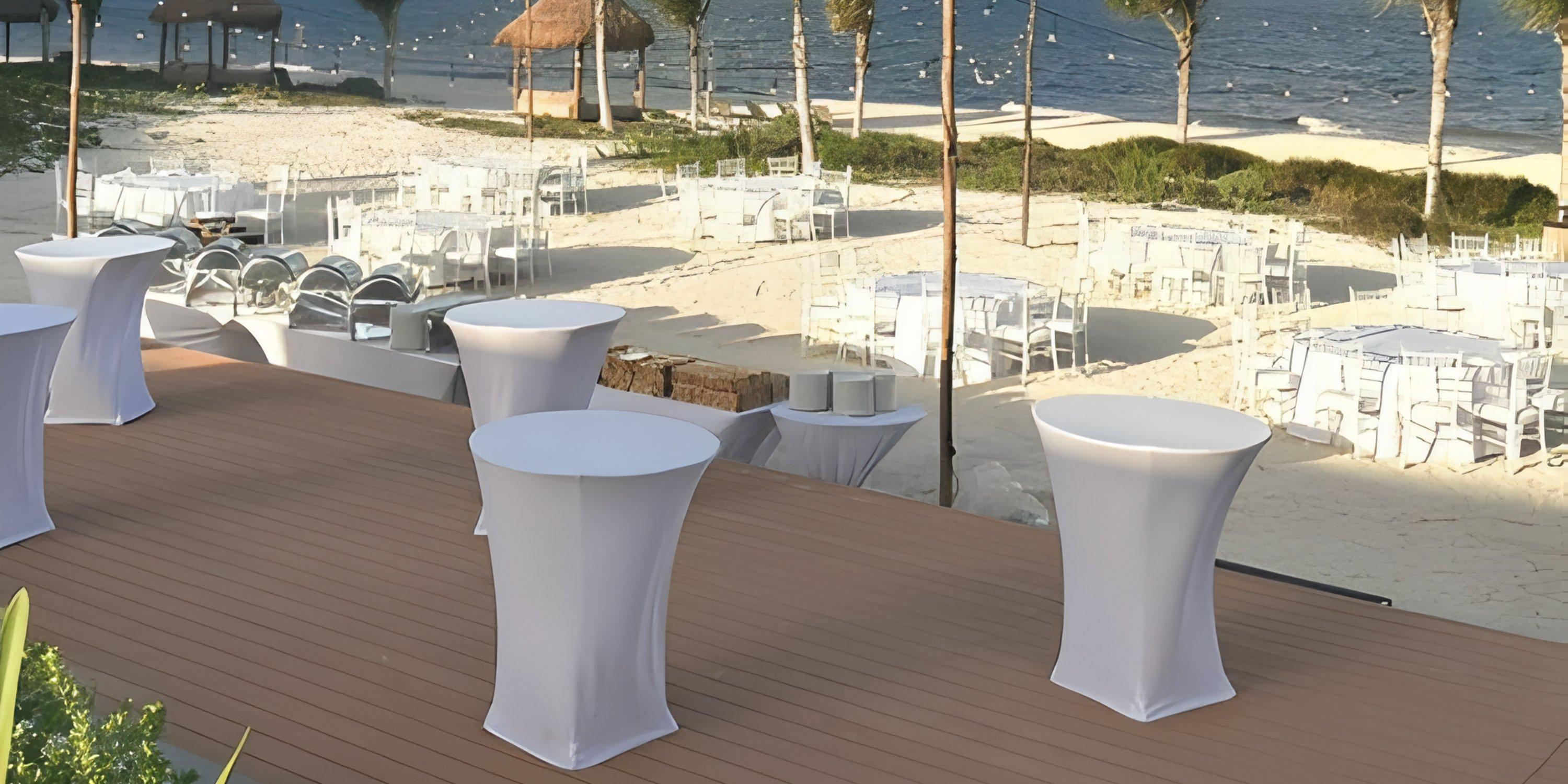 Outdoor wedding setup at Haven Riviera Cancun with cocktail and dining tables in white linens.