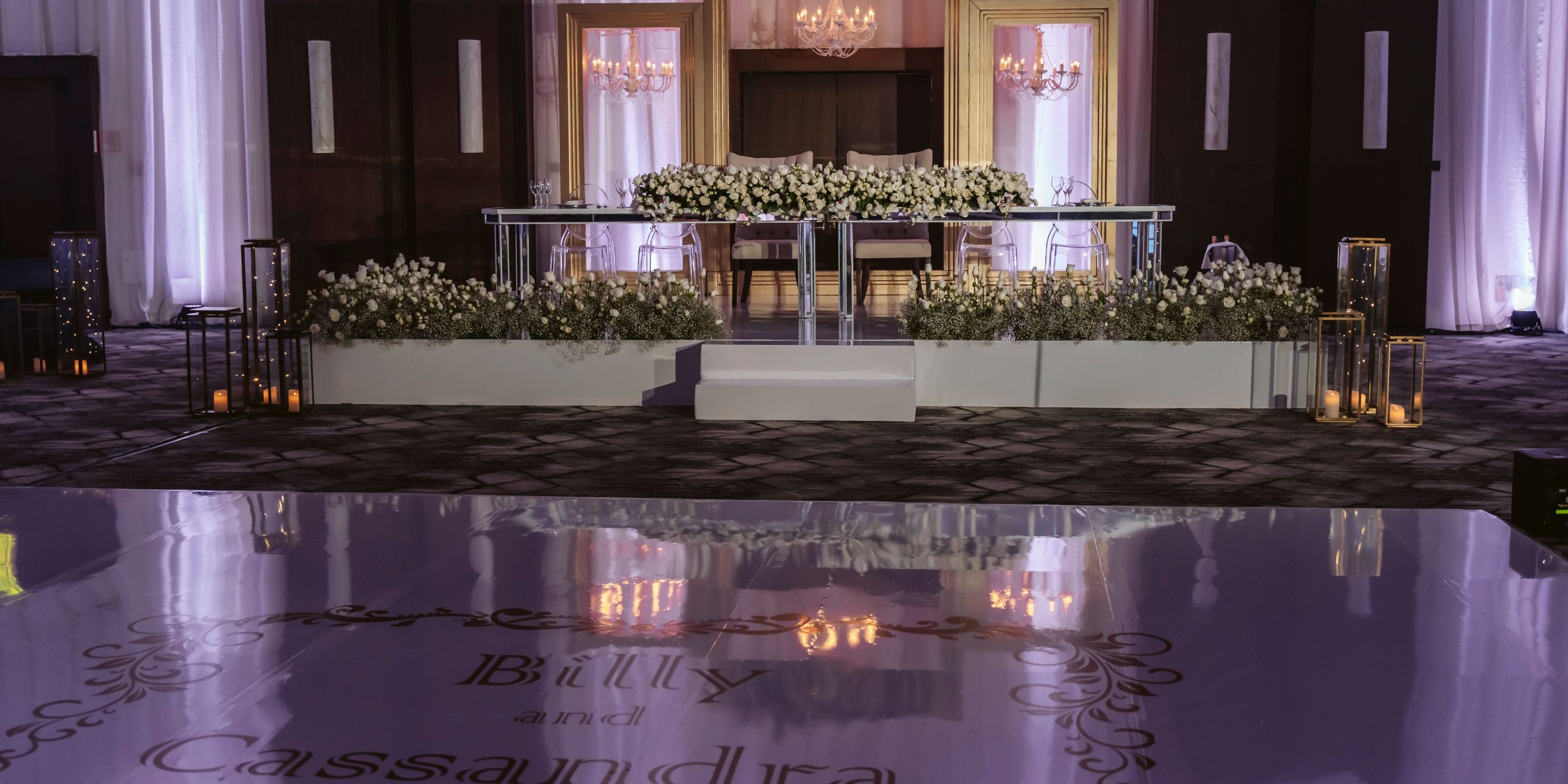 Le Blanc Spa Resort Cancun: Chic destination wedding stage with flowers, mirrored aisle, and couple's names.