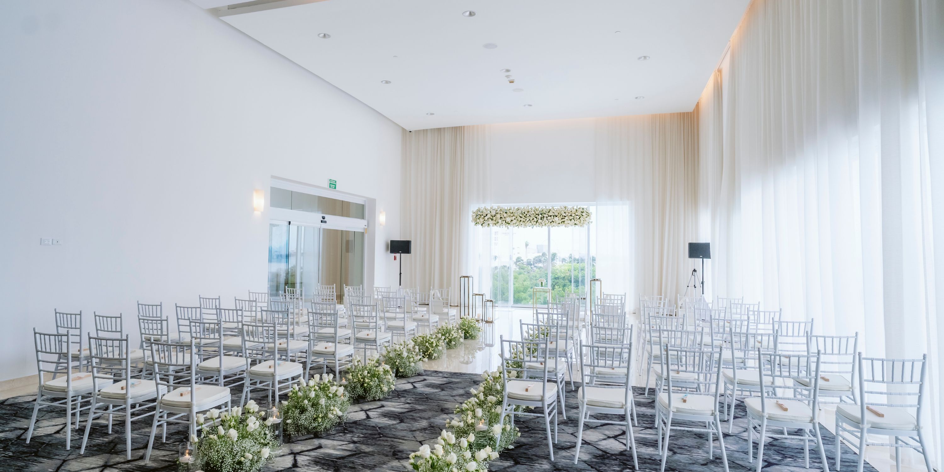 Le Blanc Spa Resort Cancun destination wedding setup, with chairs and floral arrangements lining the aisle.