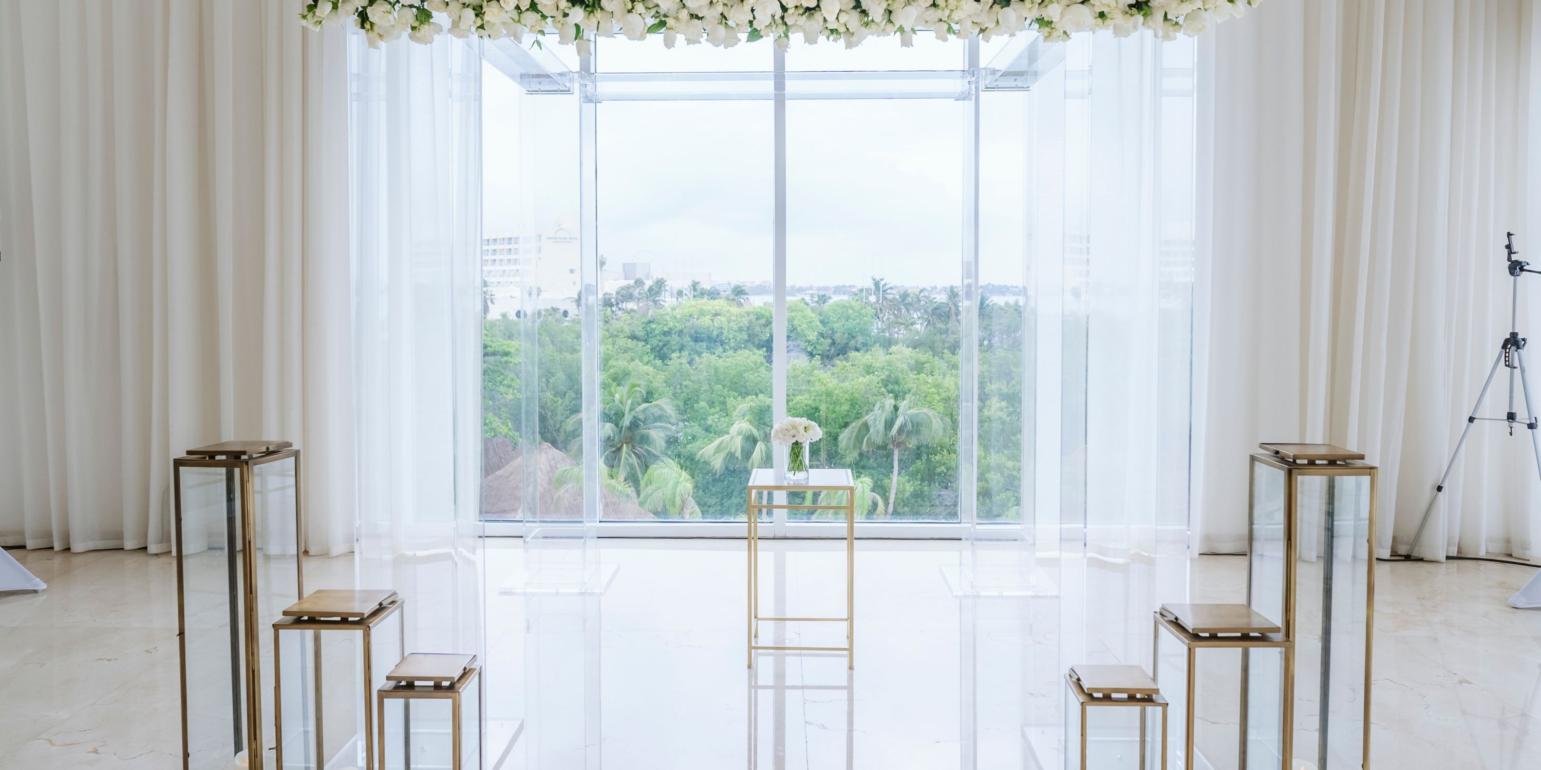 Destination wedding at Le Blanc Spa Resort Cancun, featuring glass podiums and vibrant green scenery.