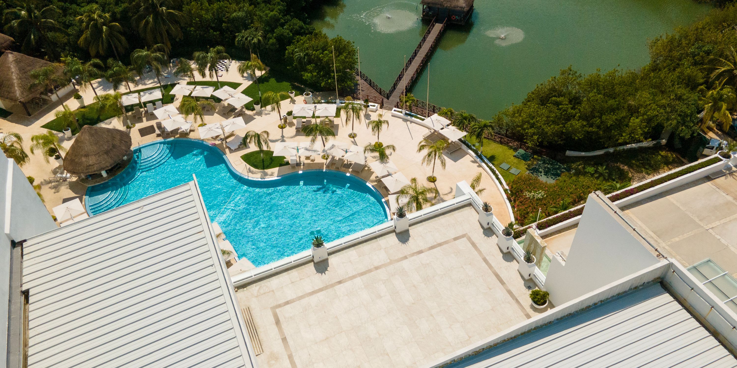 Aerial view of Le Blanc Spa Resort Cancun&mdash;picturesque pool, lounge chairs, and dock for a dream wedding.