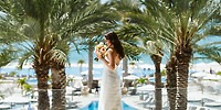 Bride in white dress at destination wedding by pool and ocean at Le Blanc Spa Resort Los Cabos, palms.