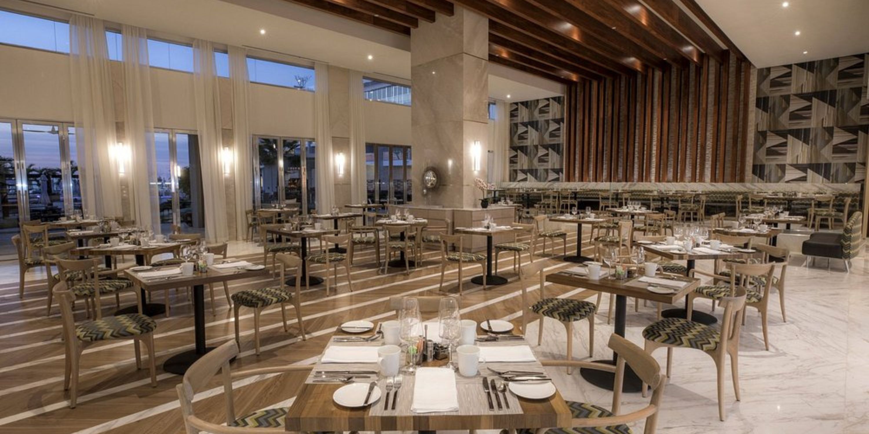 Elegant dining area at Le Blanc Spa Resort Los Cabos, perfect for a destination wedding, with set tables and large windows.