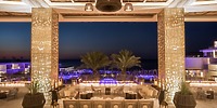 Open-air lobby at Le Blanc Spa Resort Los Cabos, ideal for a destination wedding, at dusk with pool view.