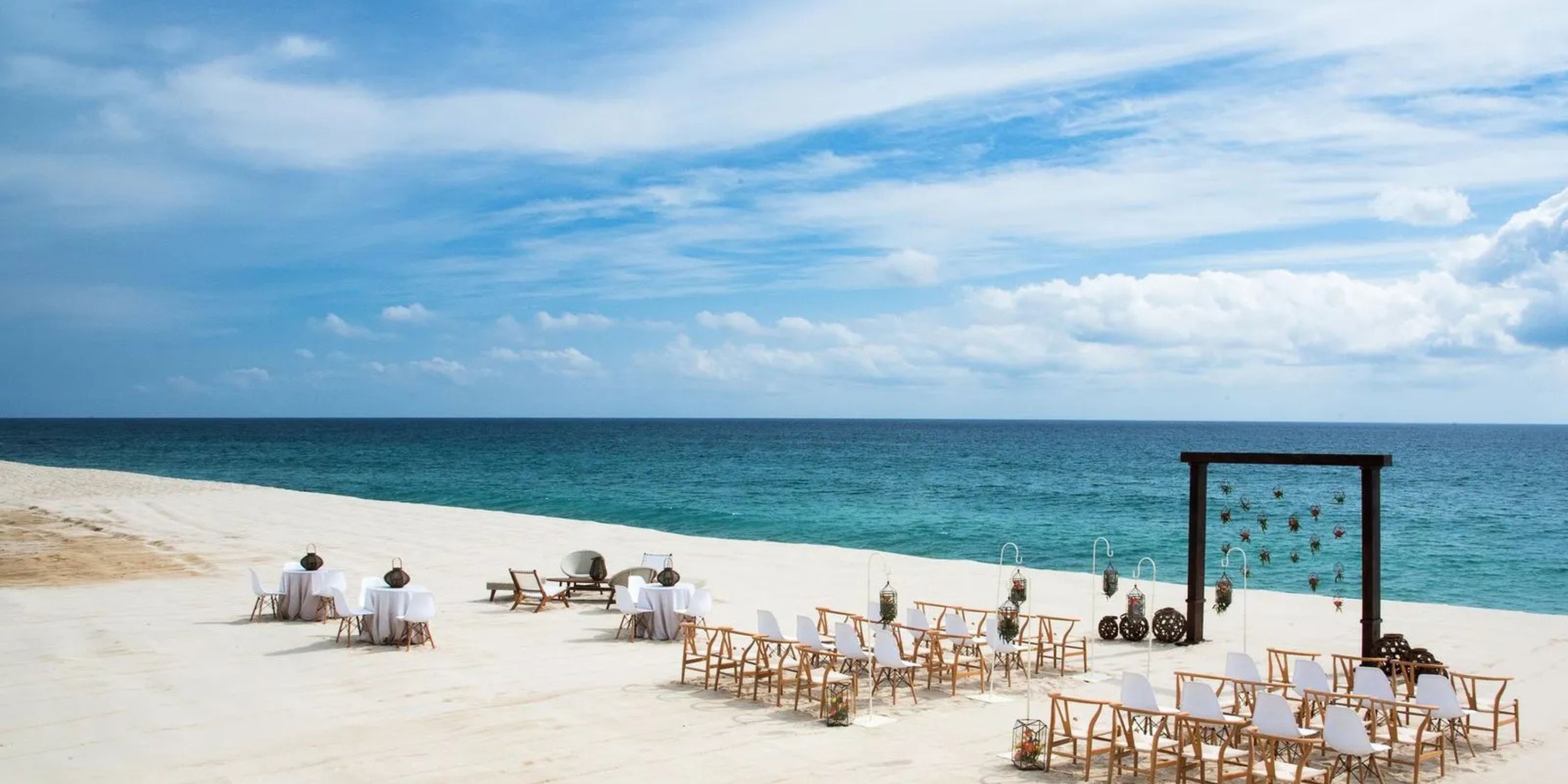 Destination wedding seating at Le Blanc Spa Resort Los Cabos overlooking the ocean under a clear blue sky.